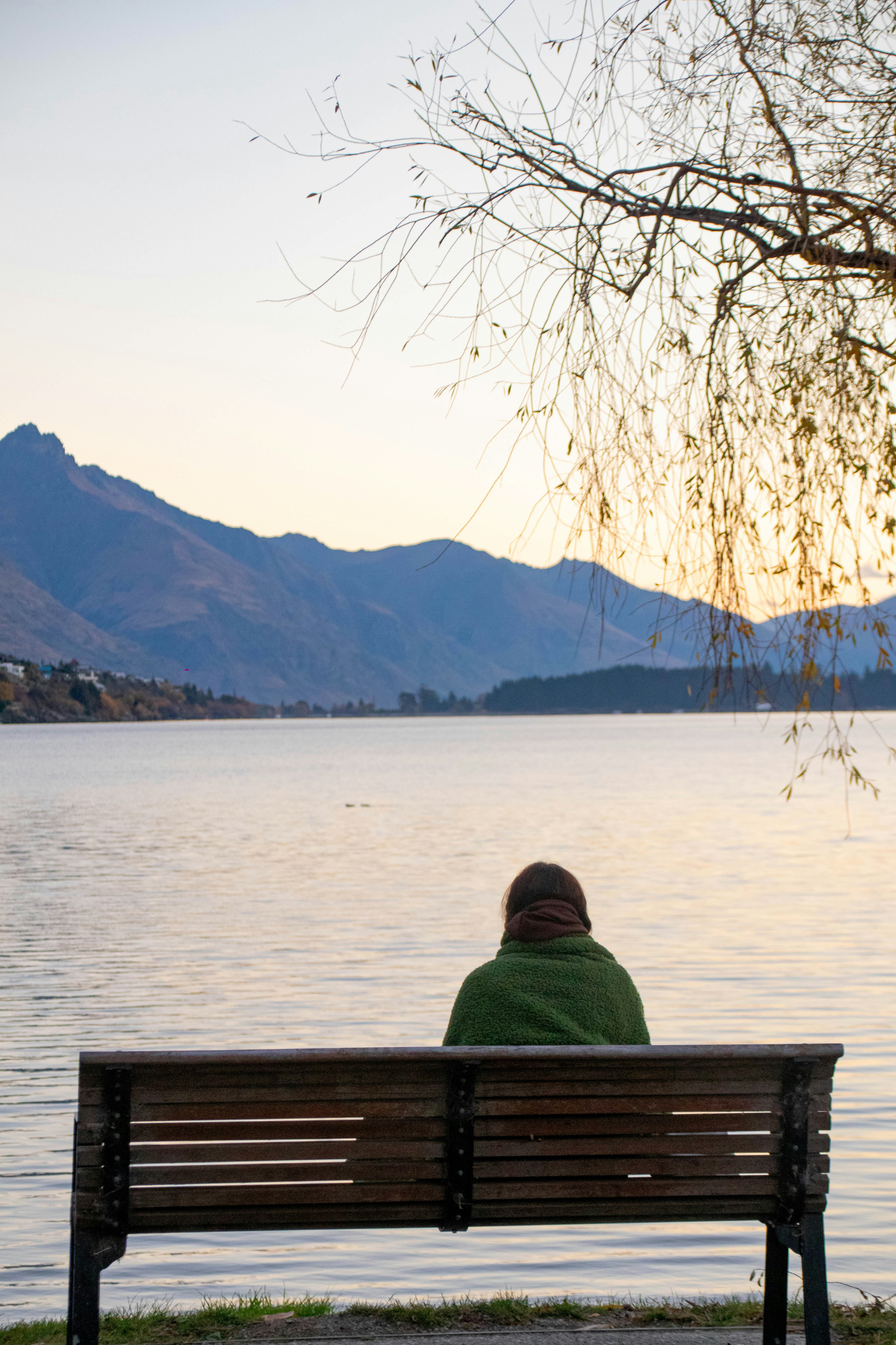 A person sitting on a bench near a body of water