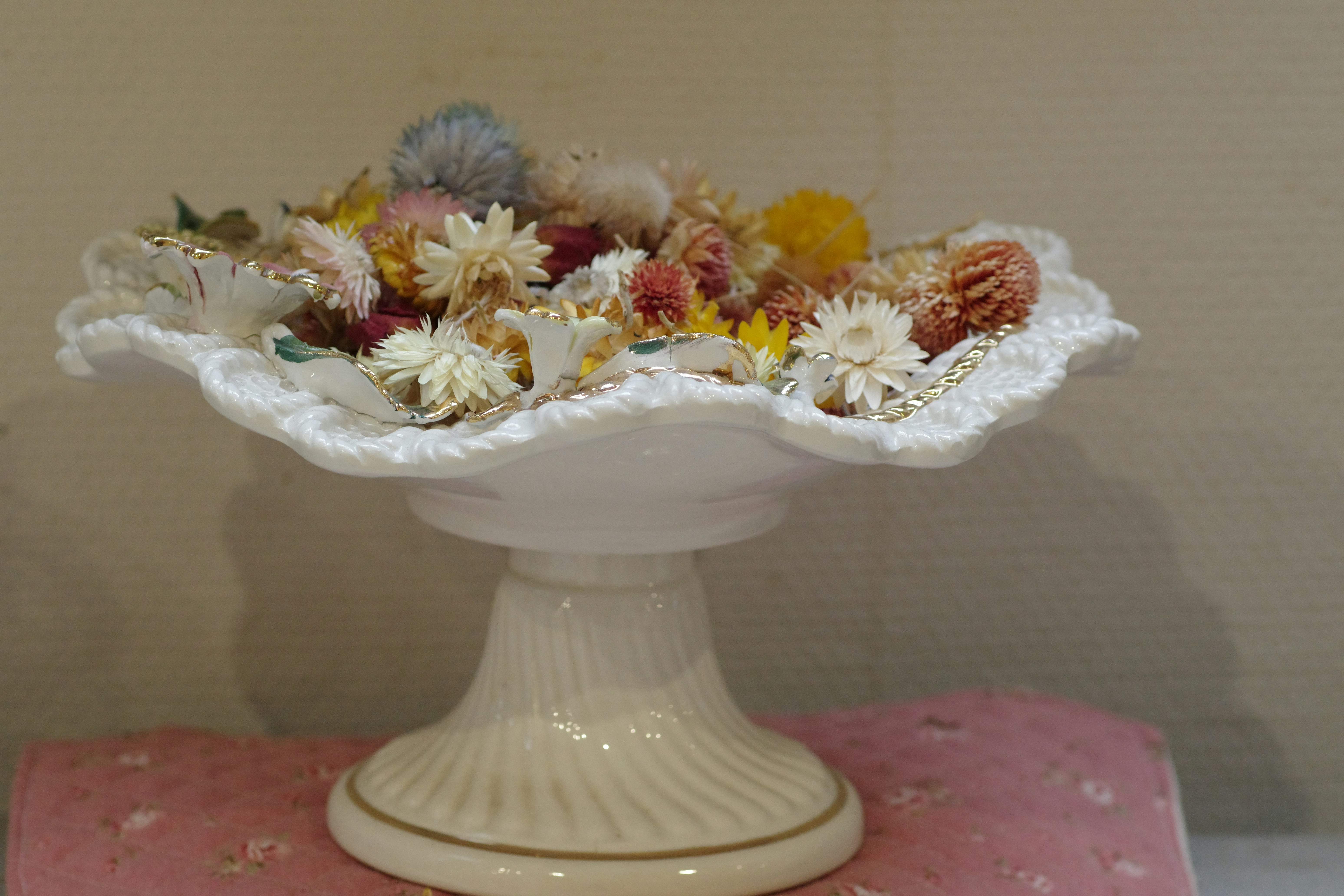 A white vase filled with lots of different types of flowers