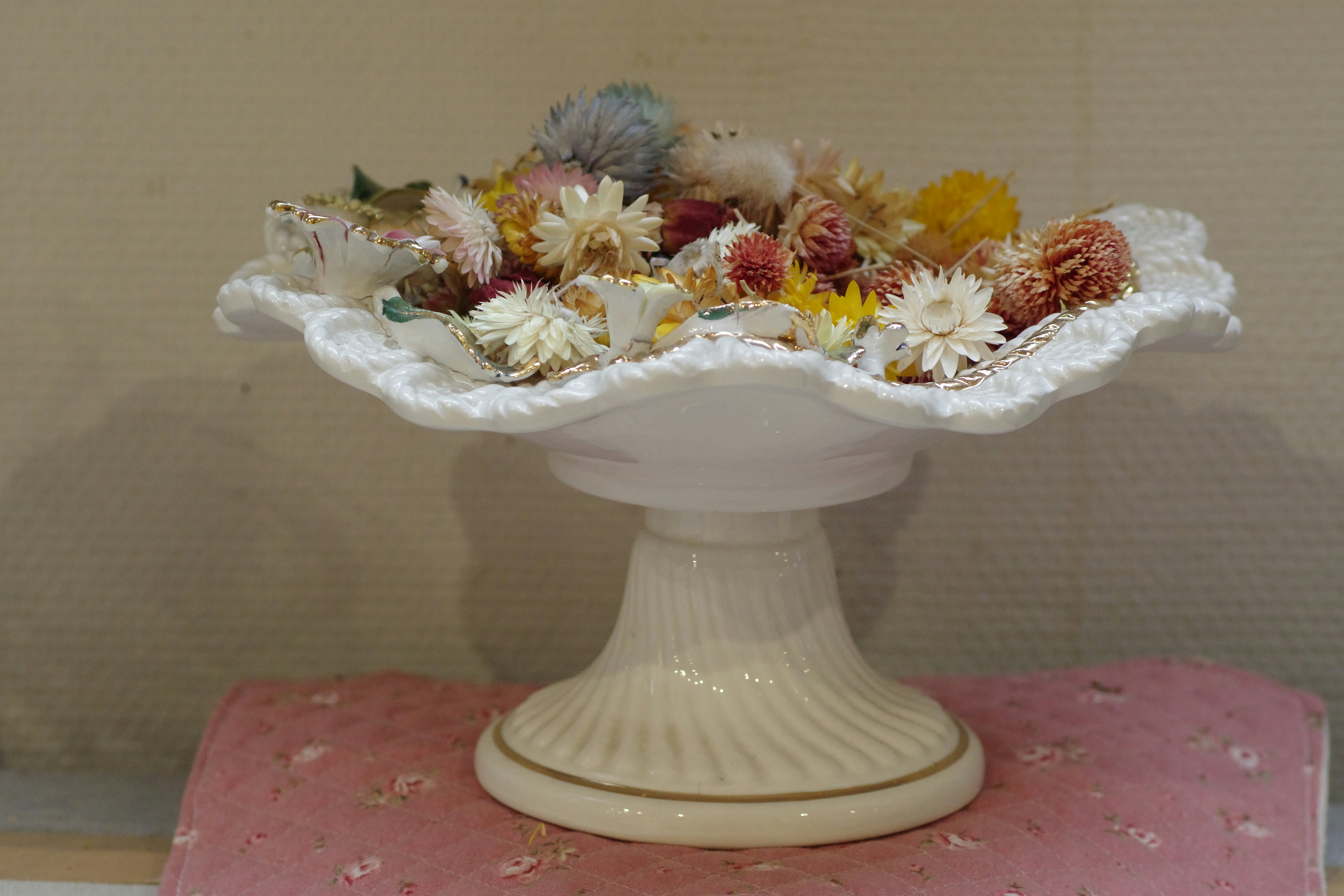 A white vase filled with lots of different types of flowers