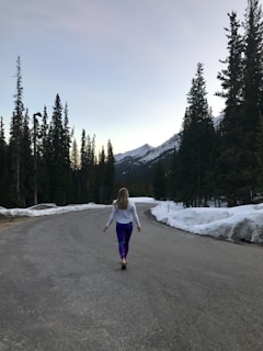 A woman walking down the middle of a road