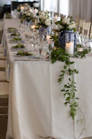 A long table with white and blue flowers and greenery