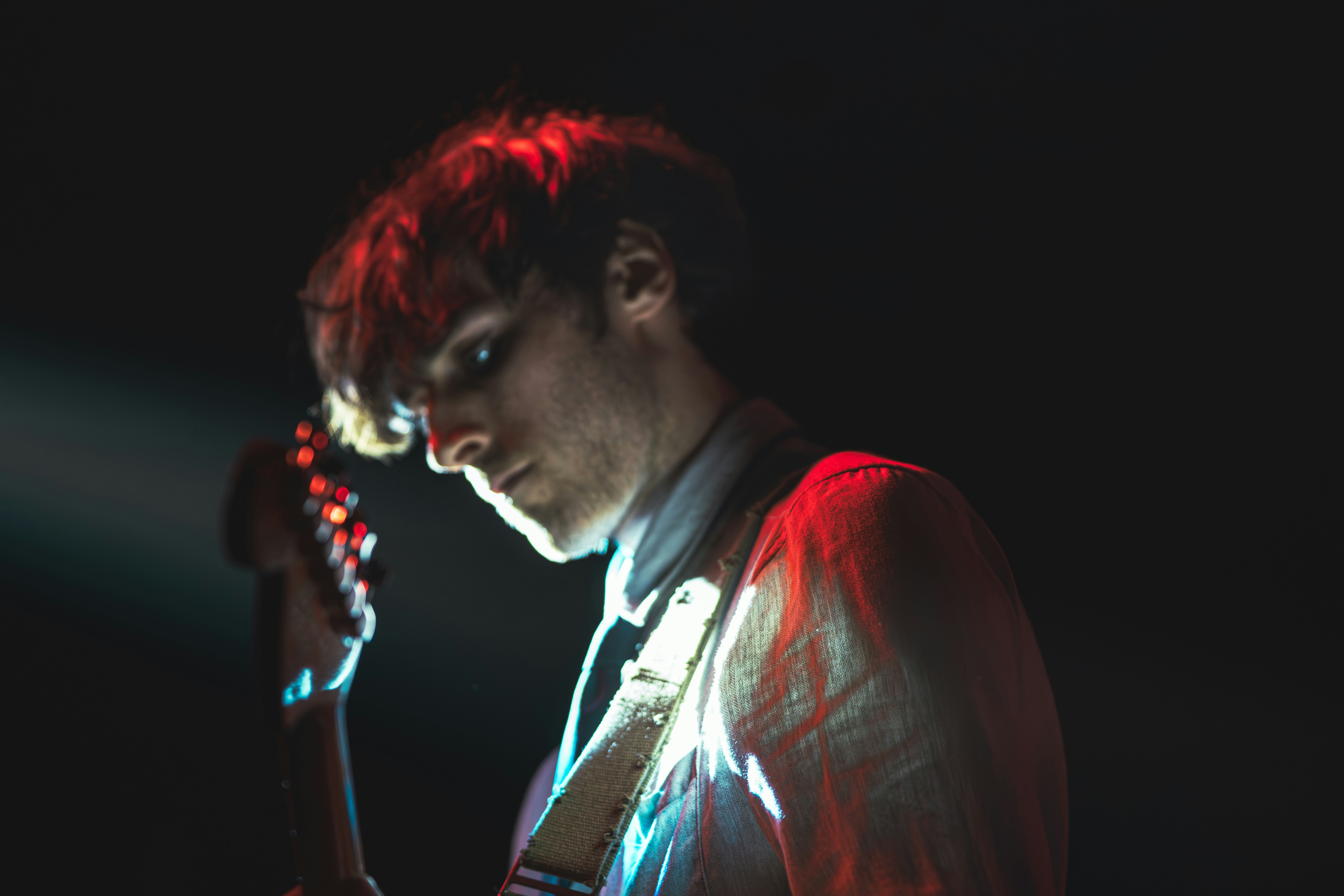 Man holding cell phone capturing live music performance