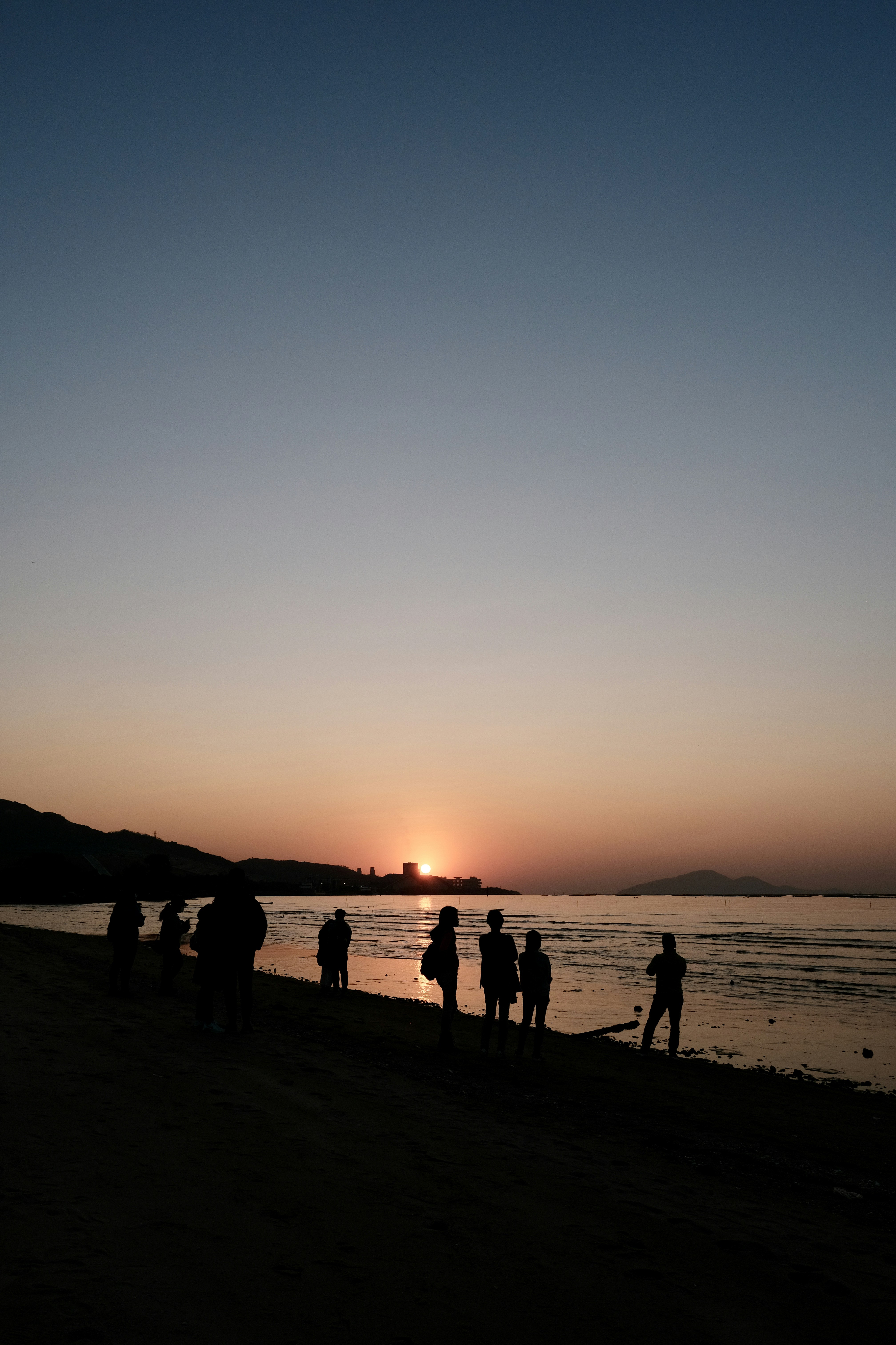 A group of people standing on top of a beach