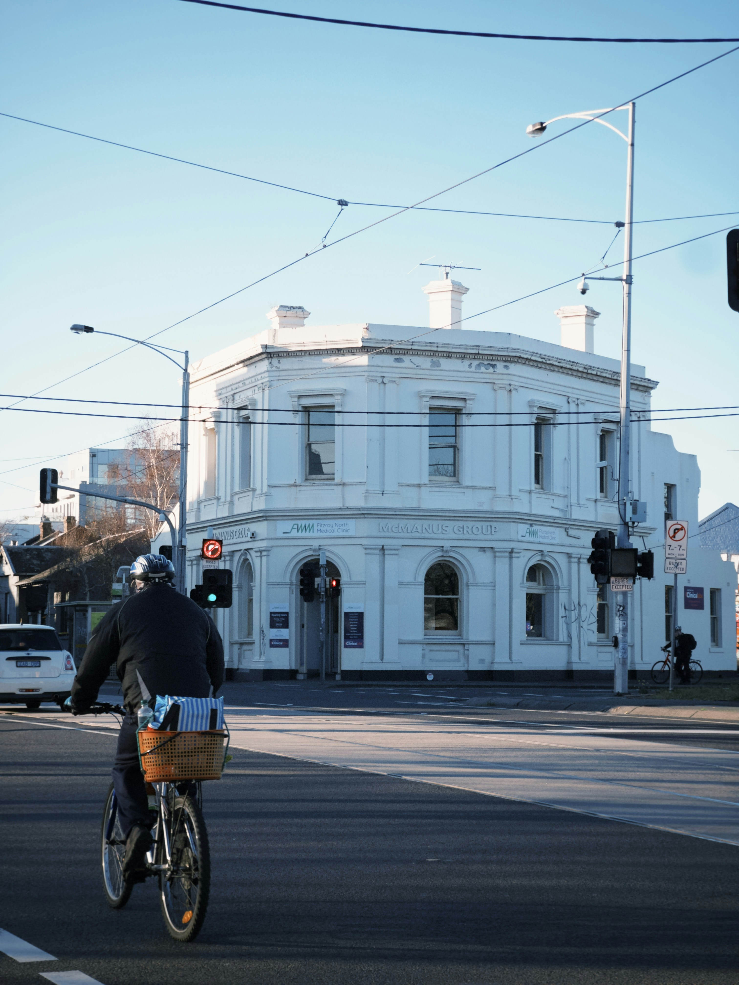 A man riding a bike down a street next to a traffic light