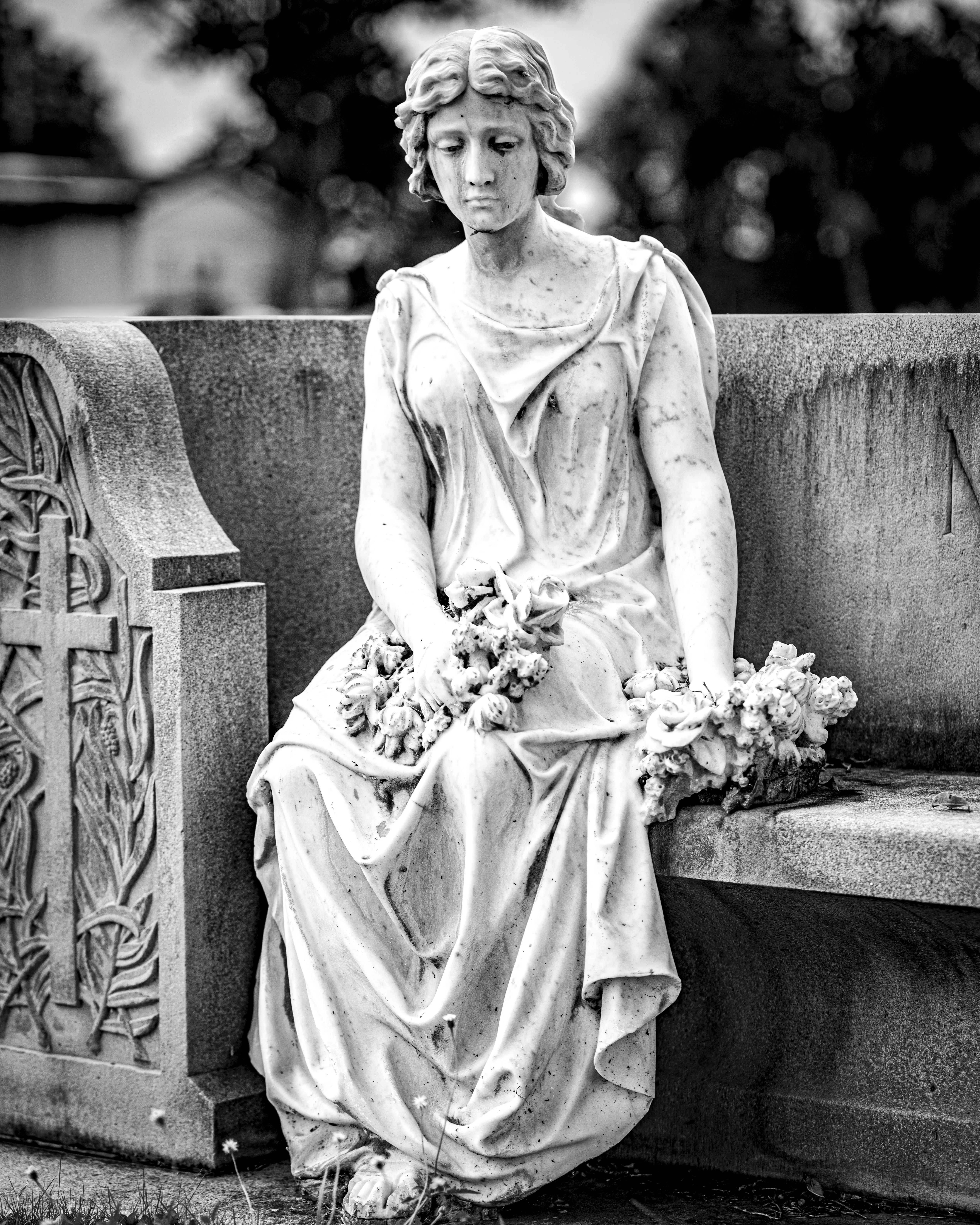 A black and white photo of a woman sitting on a bench