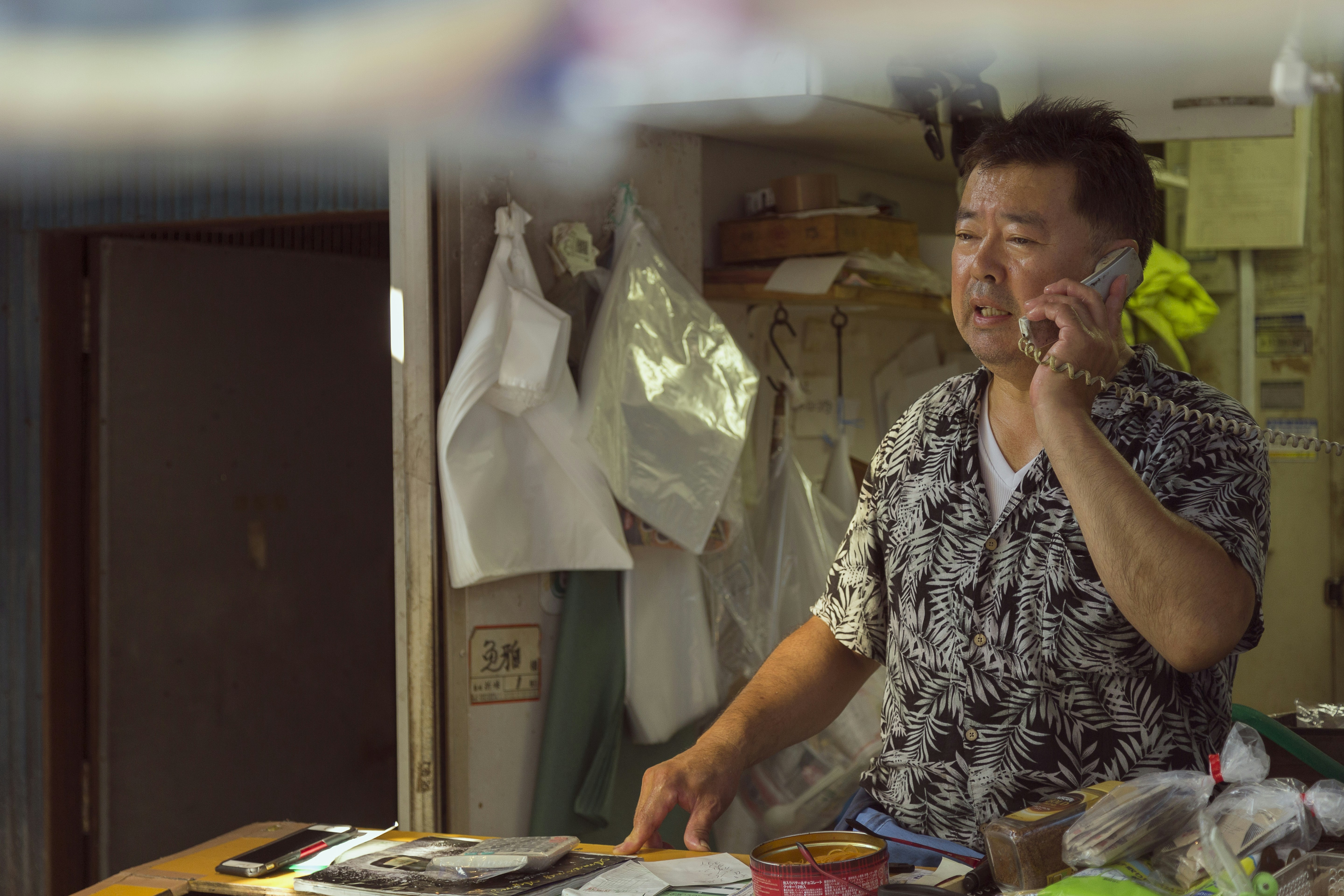 A man talking on a cell phone while standing in a kitchen