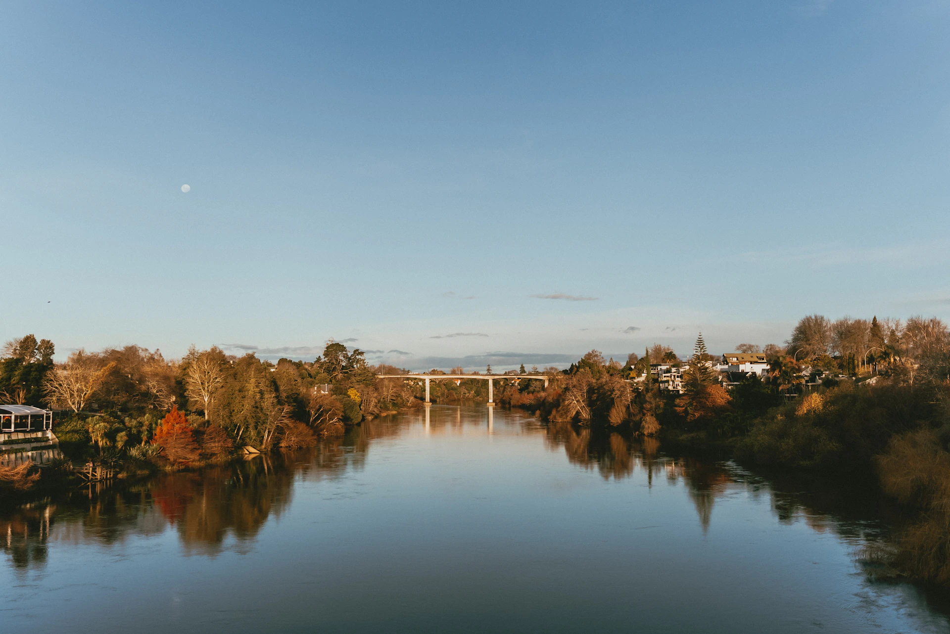 A body of water with a bridge in the background