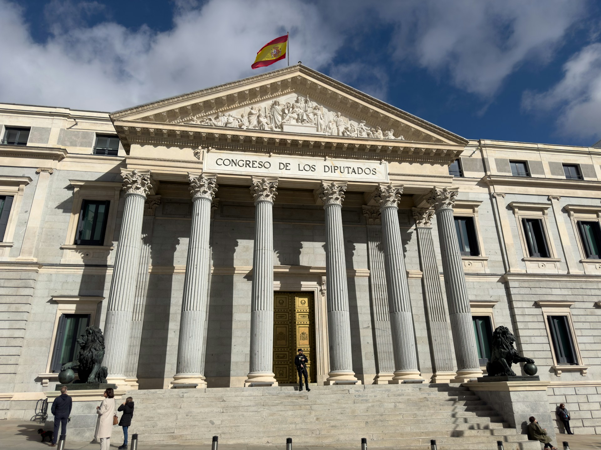 A large building with columns and a flag on top