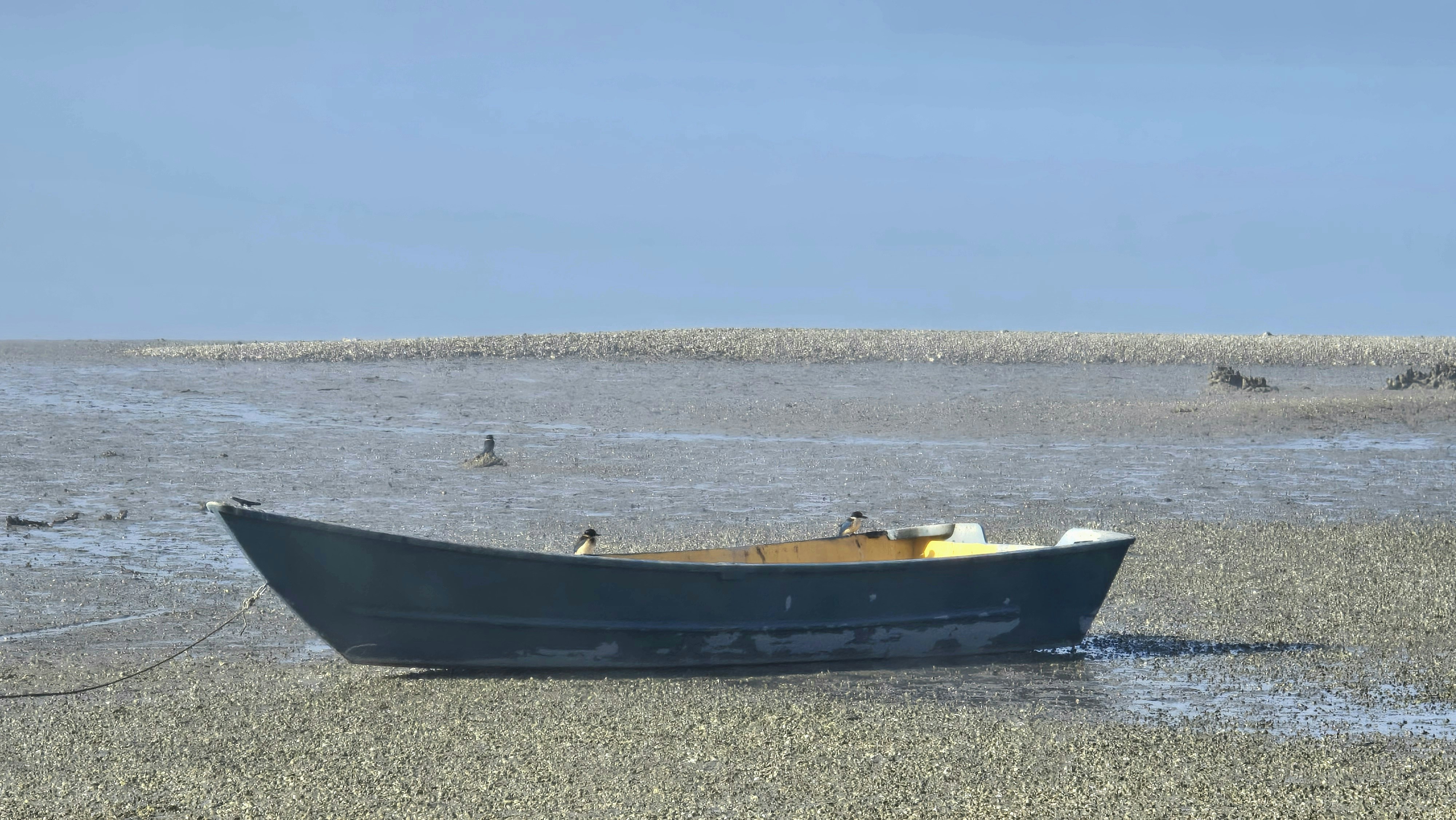A small boat sitting on top of a sandy beach