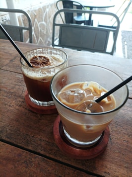 A couple of drinks sitting on top of a wooden table