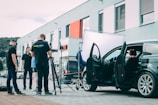 A group of people standing next to a car