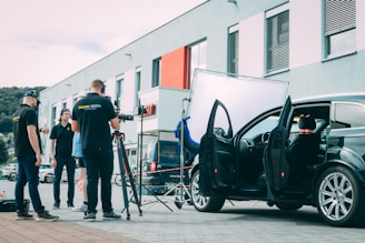 A group of people standing next to a car