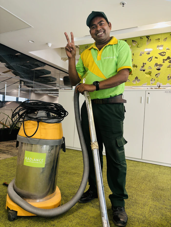 Facility staff member cleaning with a vacuum