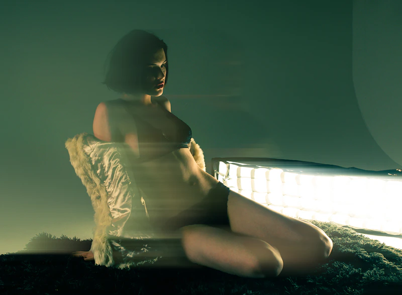 attractive woman sitting on a bed in a private room