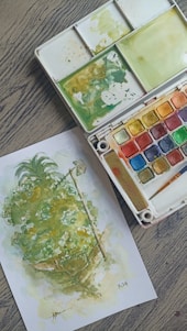 A box of watercolors and a painting of a tree