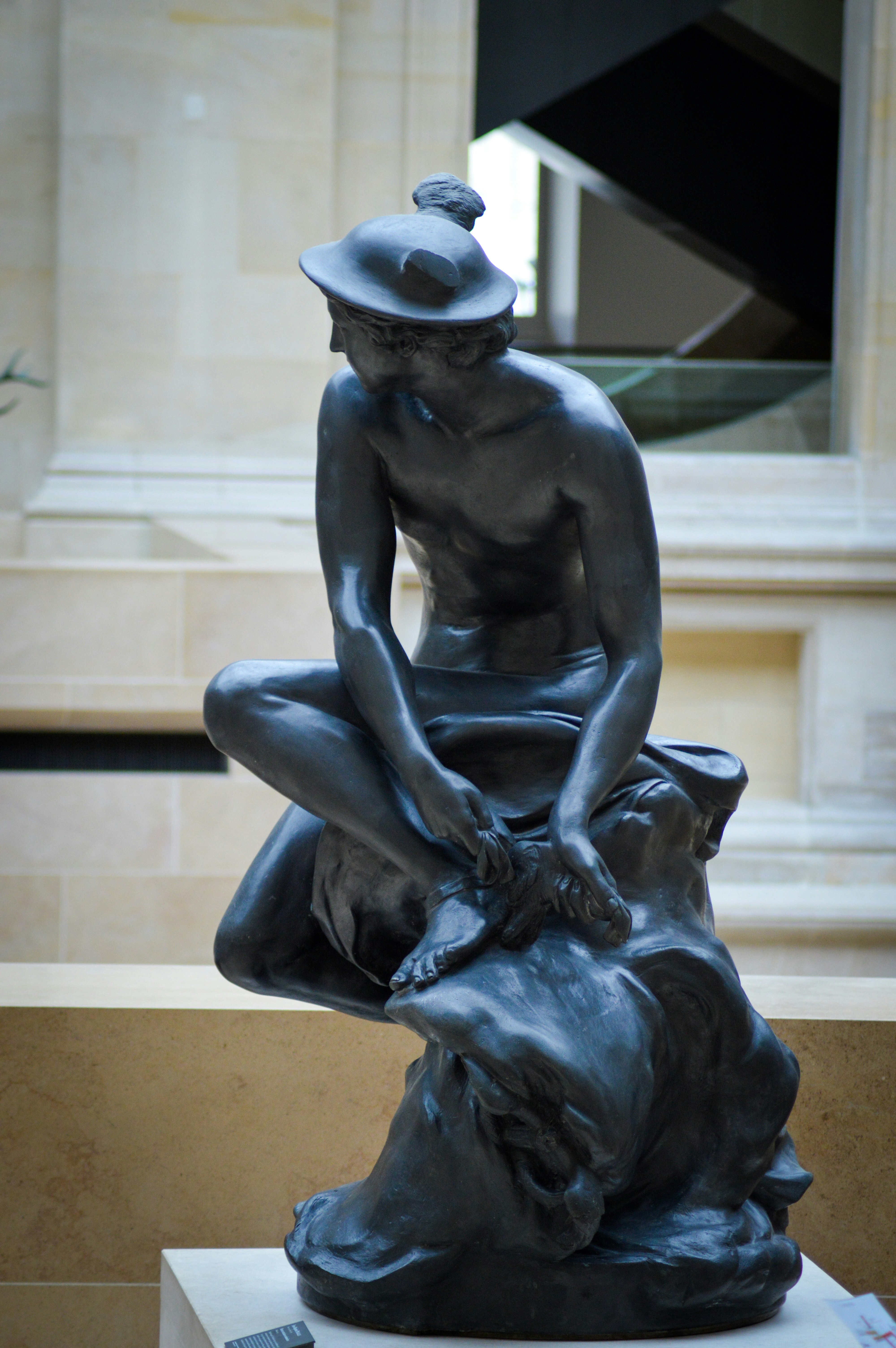 A statue of a man sitting on top of a rock