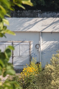 A white building with two doors and a fence
