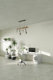 A white room with a desk, chair and potted plants