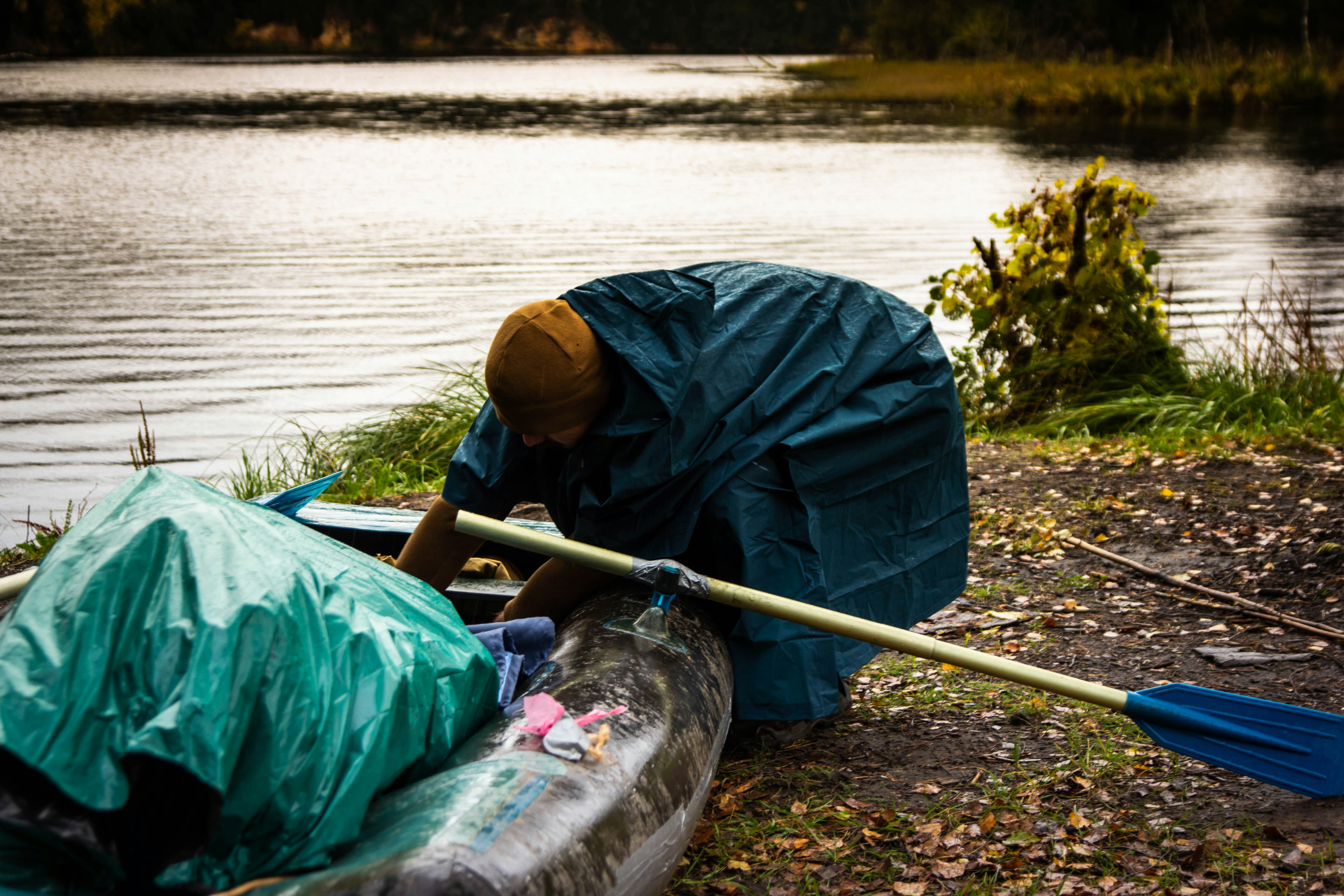 A man in a blue jacket and a blue kayak