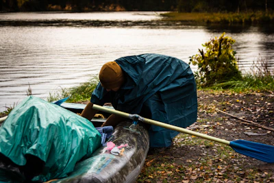 A man in a blue jacket and a blue kayak