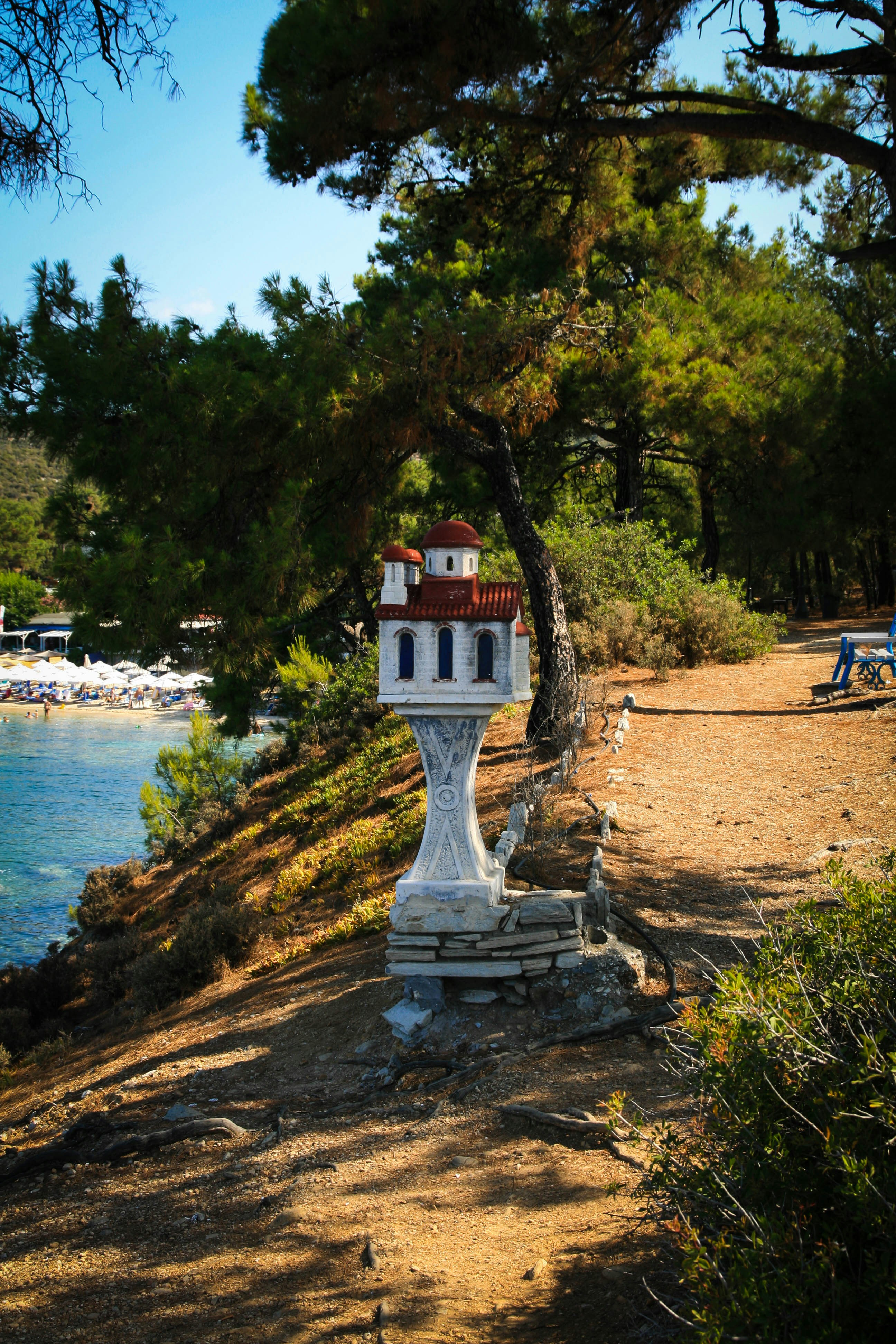 Ein weißer Uhrenturm steht am Straßenrand