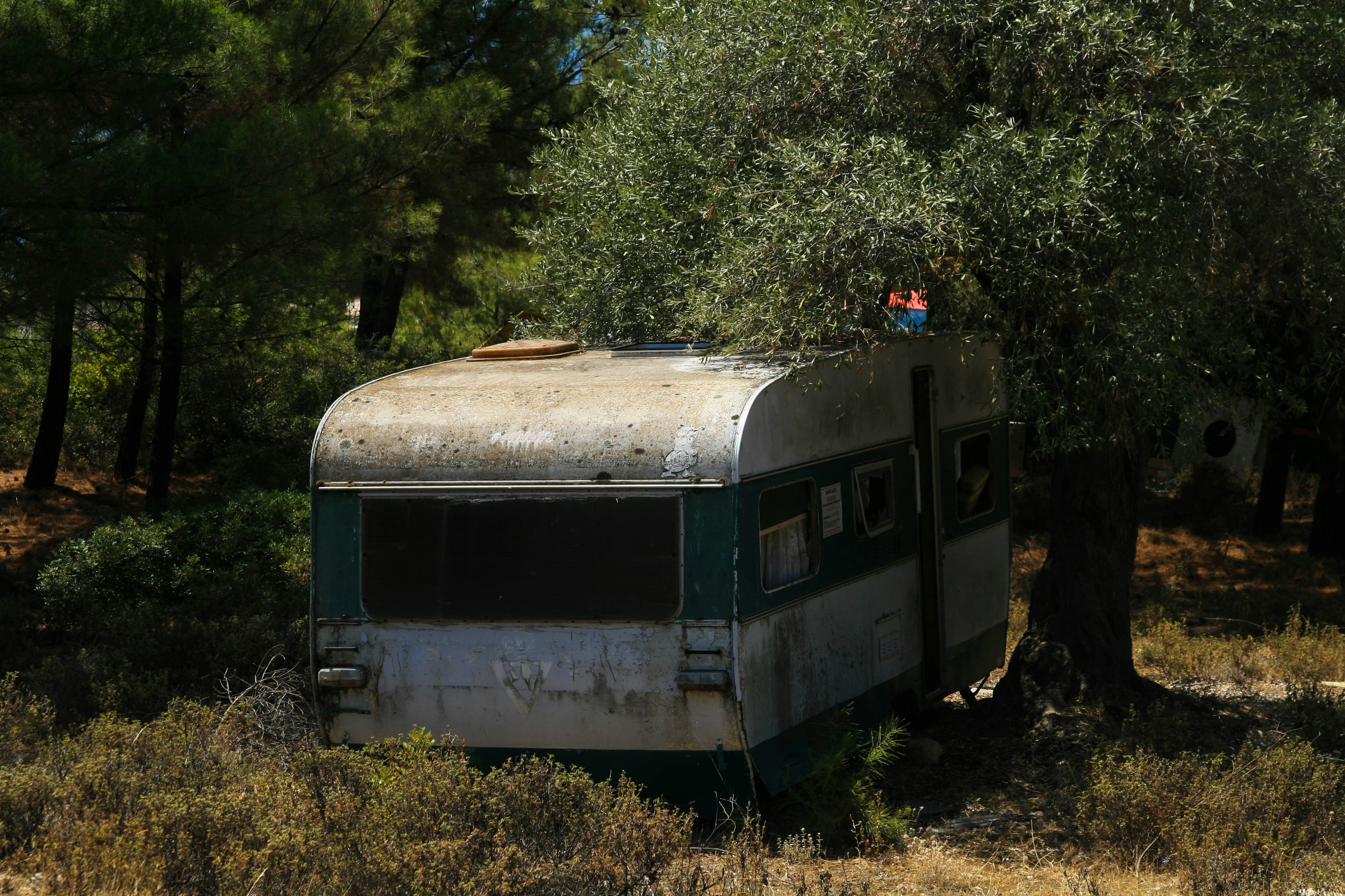 An old trailer sitting in the middle of a field