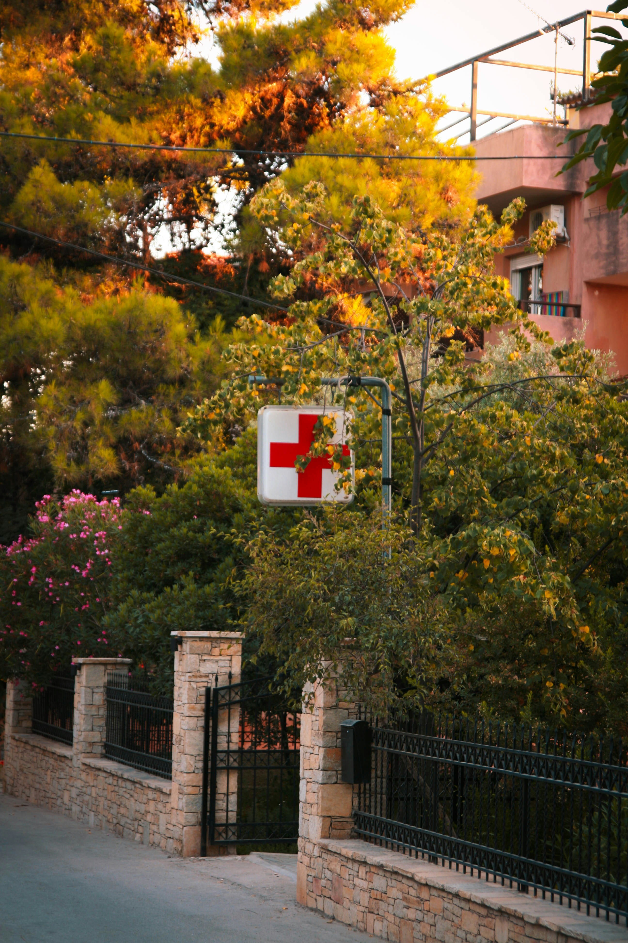 A red cross sign hanging from the side of a building