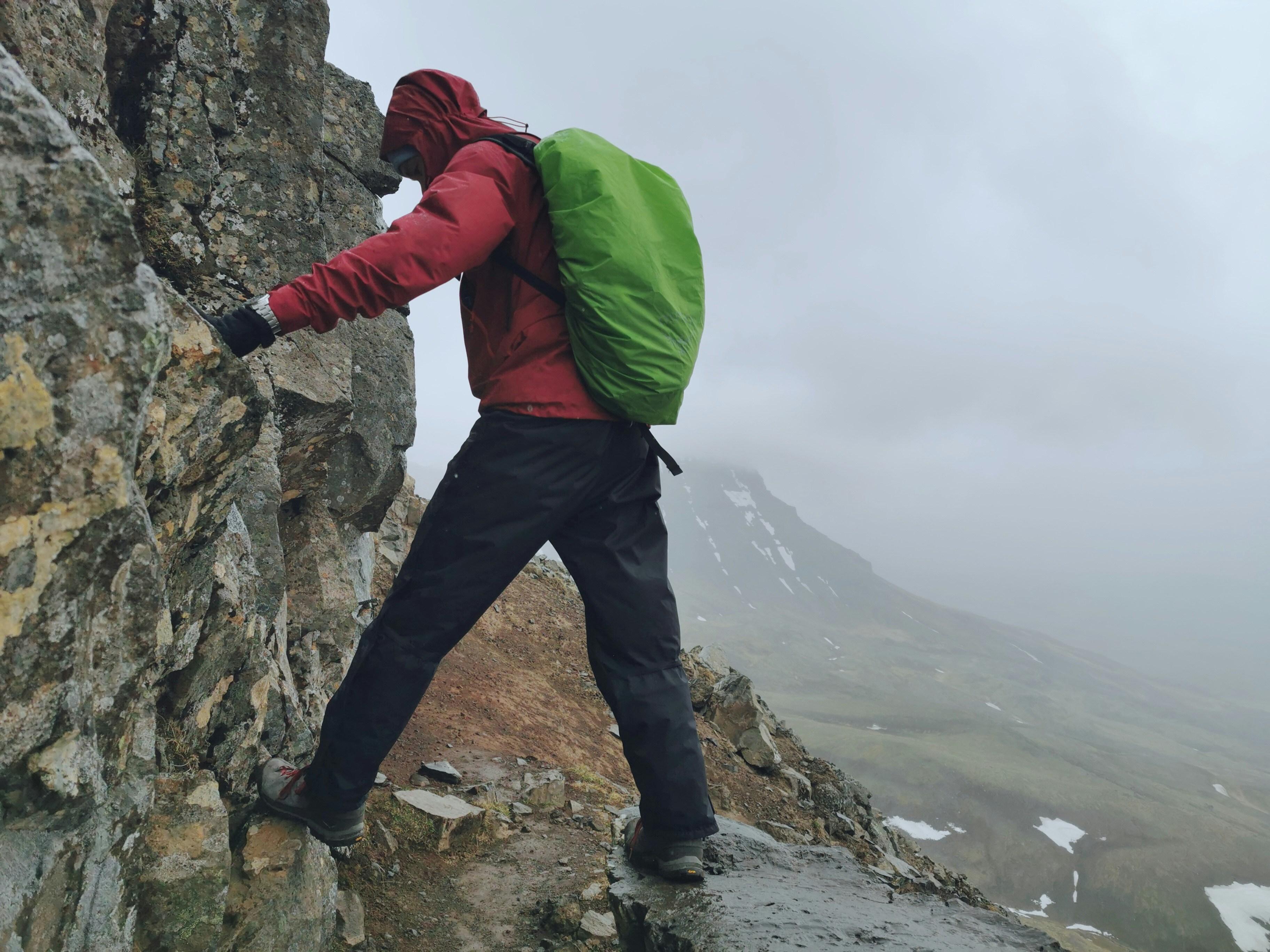 A man climbing up the side of a mountain