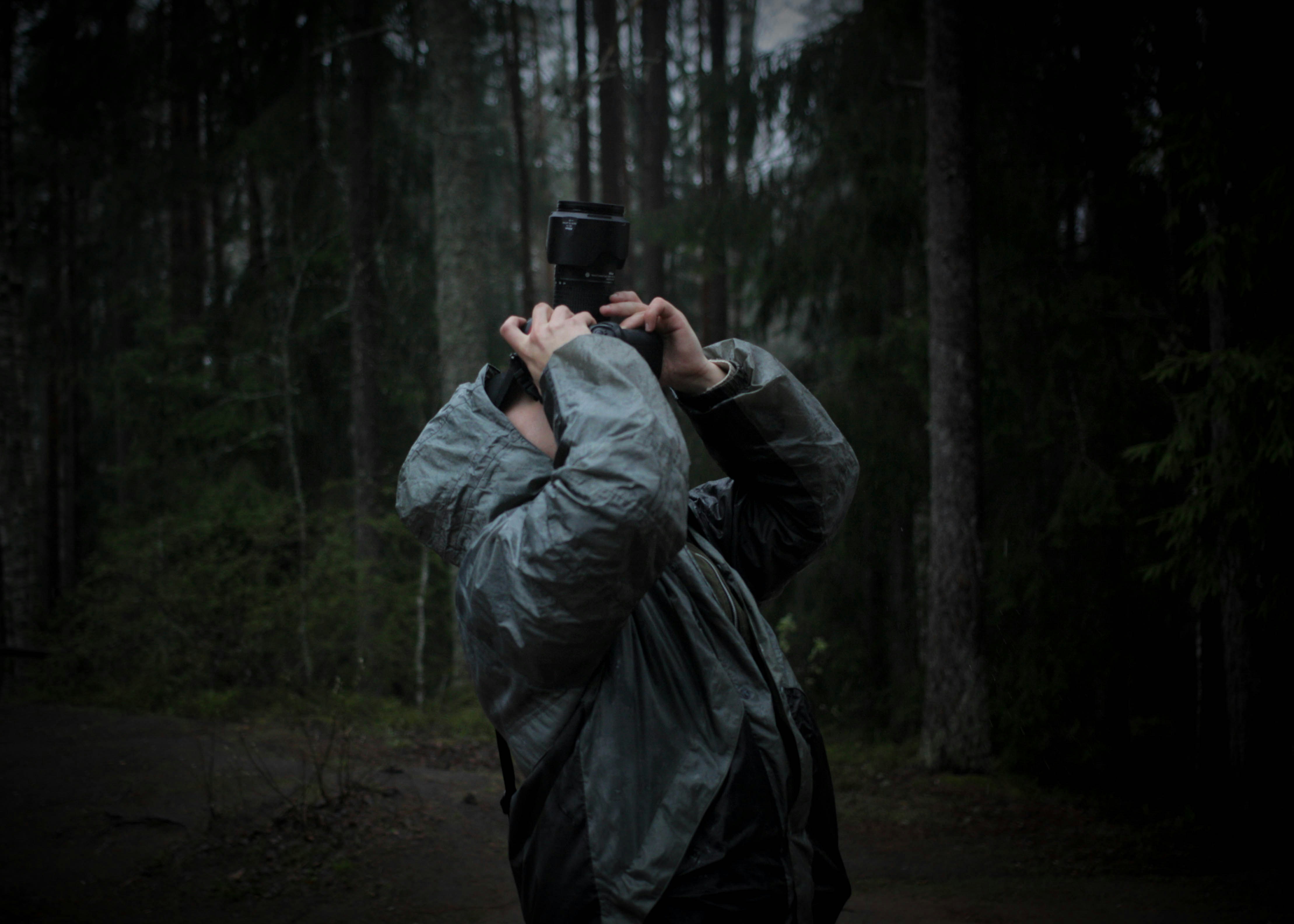 Una persona tomando una foto con una cámara en el bosque