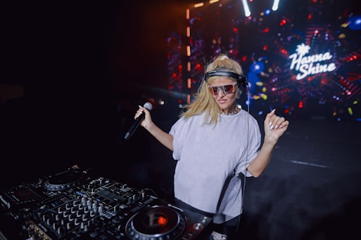 A woman standing in front of a dj mixer