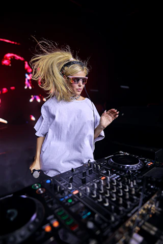 A woman standing in front of a dj mixer