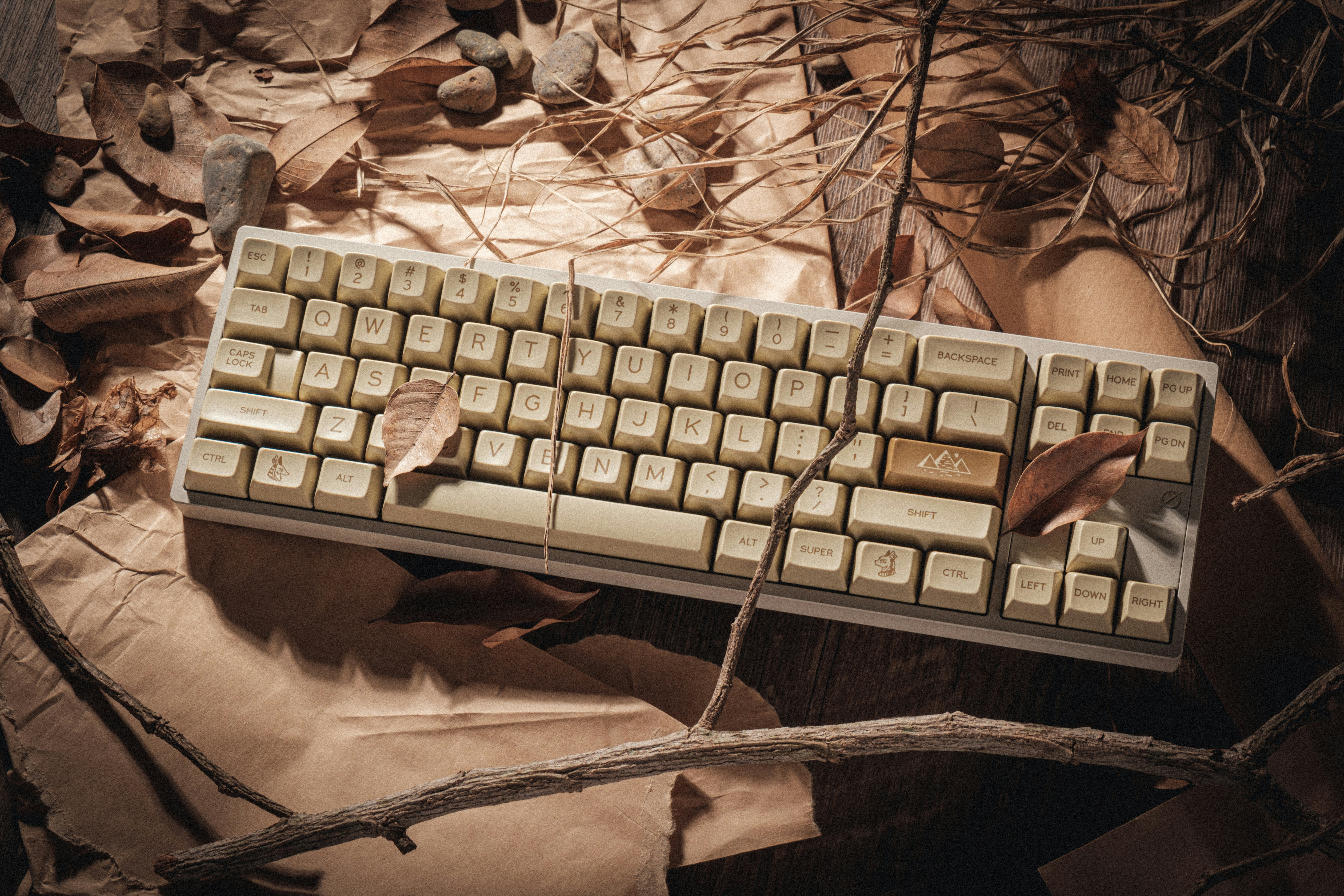 A computer keyboard sitting on top of a pile of leaves