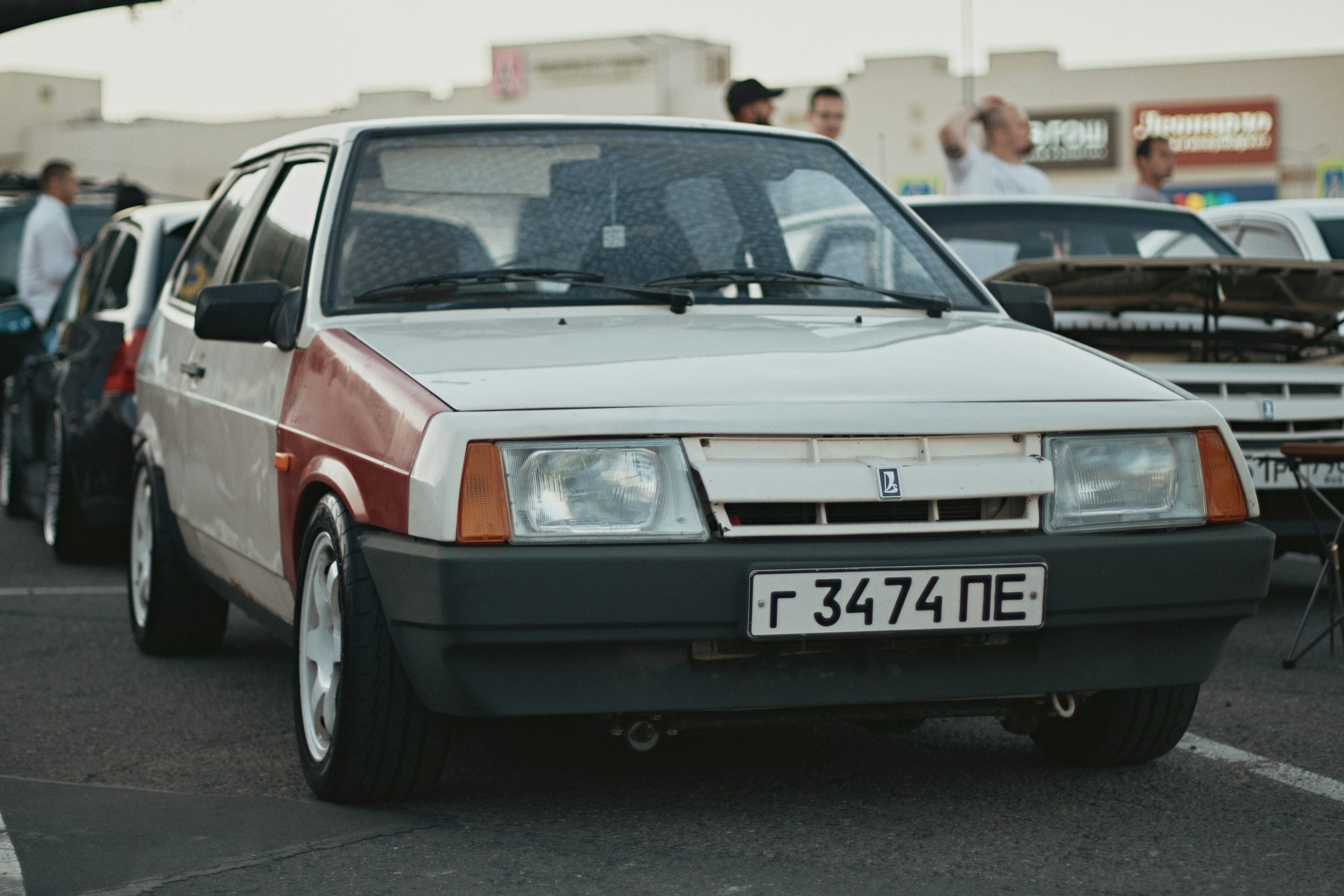 A group of people standing around a parked car