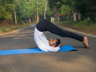 A woman doing a yoga pose on a blue mat