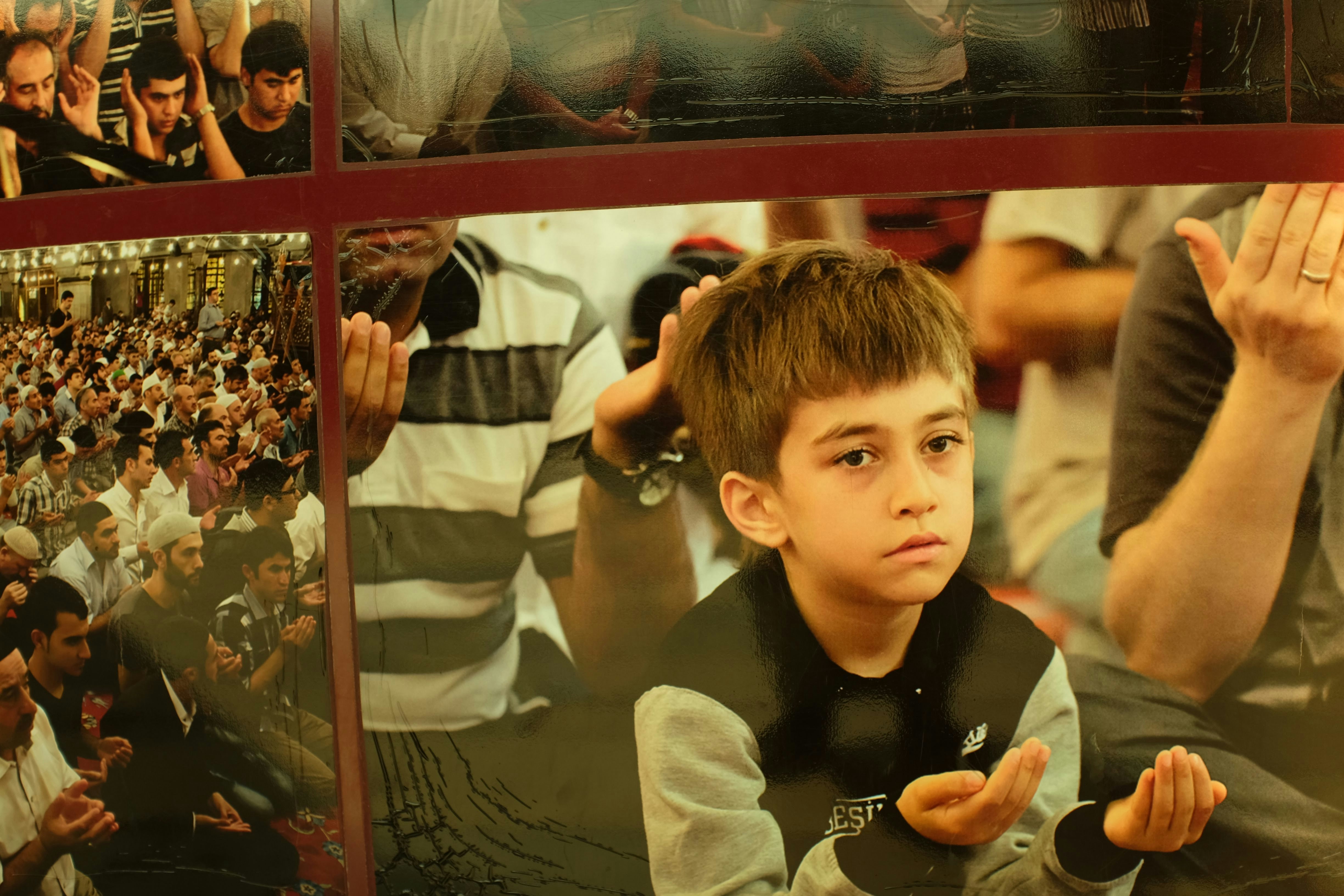 A young boy sitting in front of a crowd of people