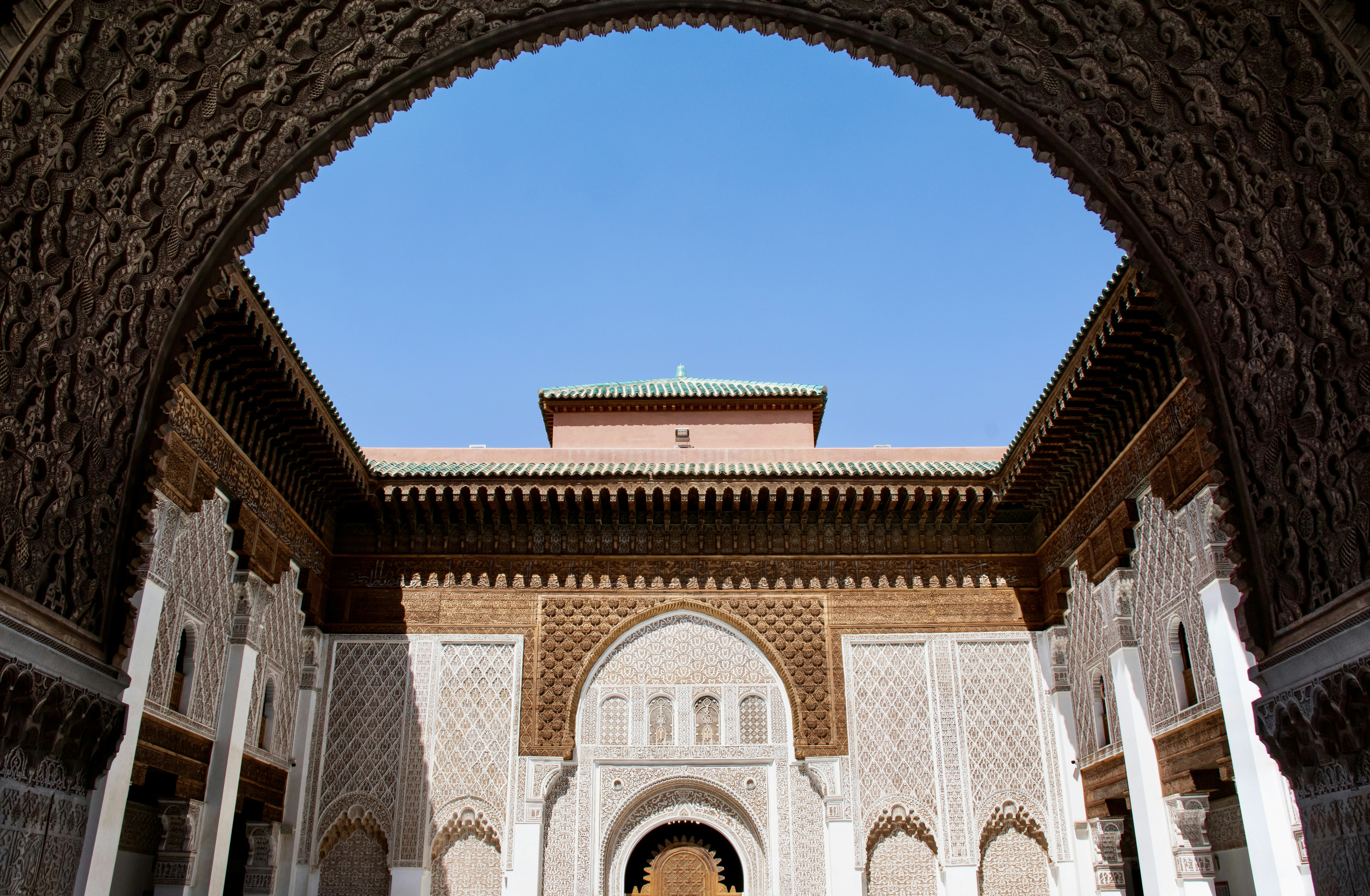 A building with arches and a clock tower in the background