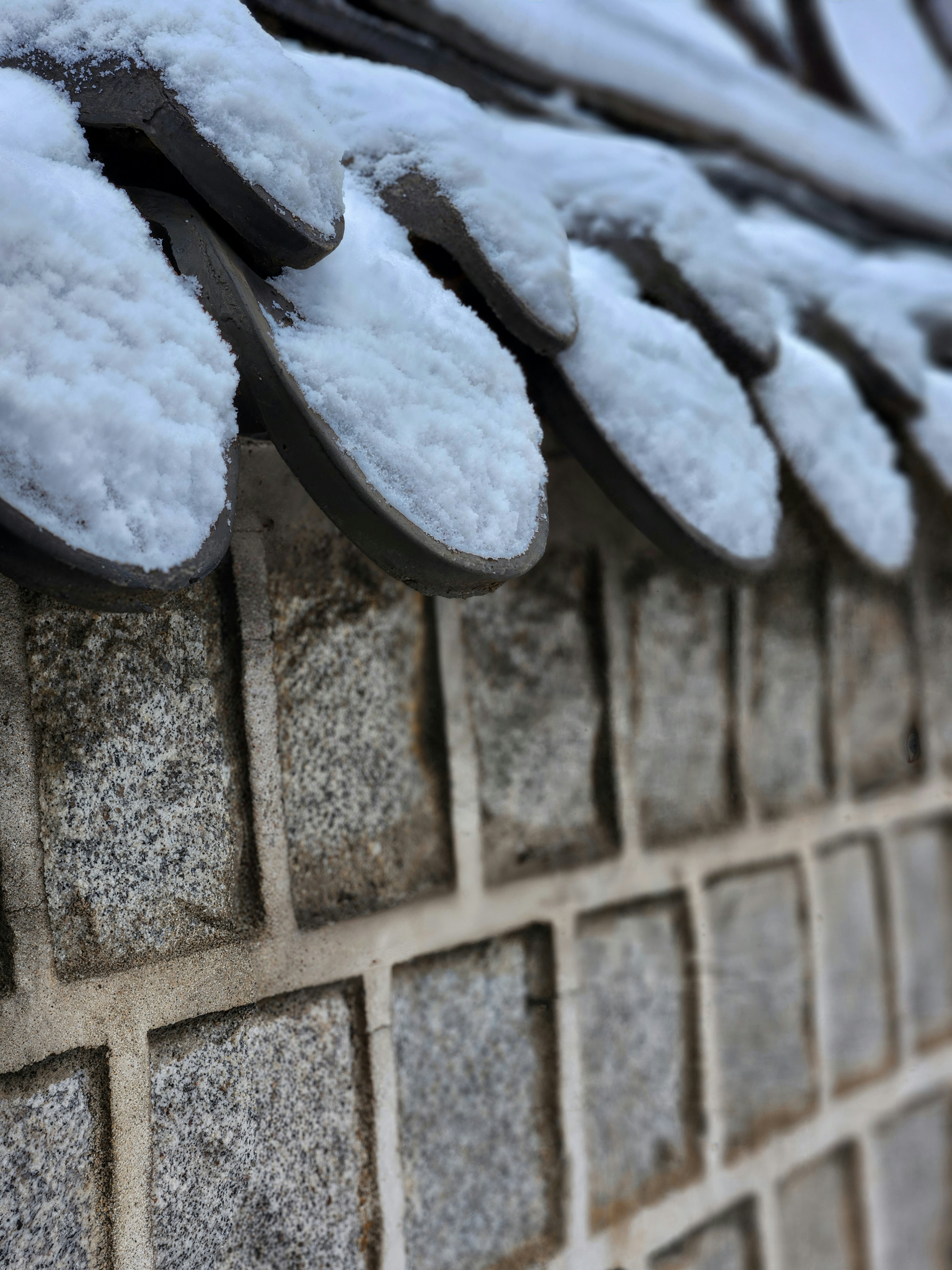 A close up of a brick wall covered in snow