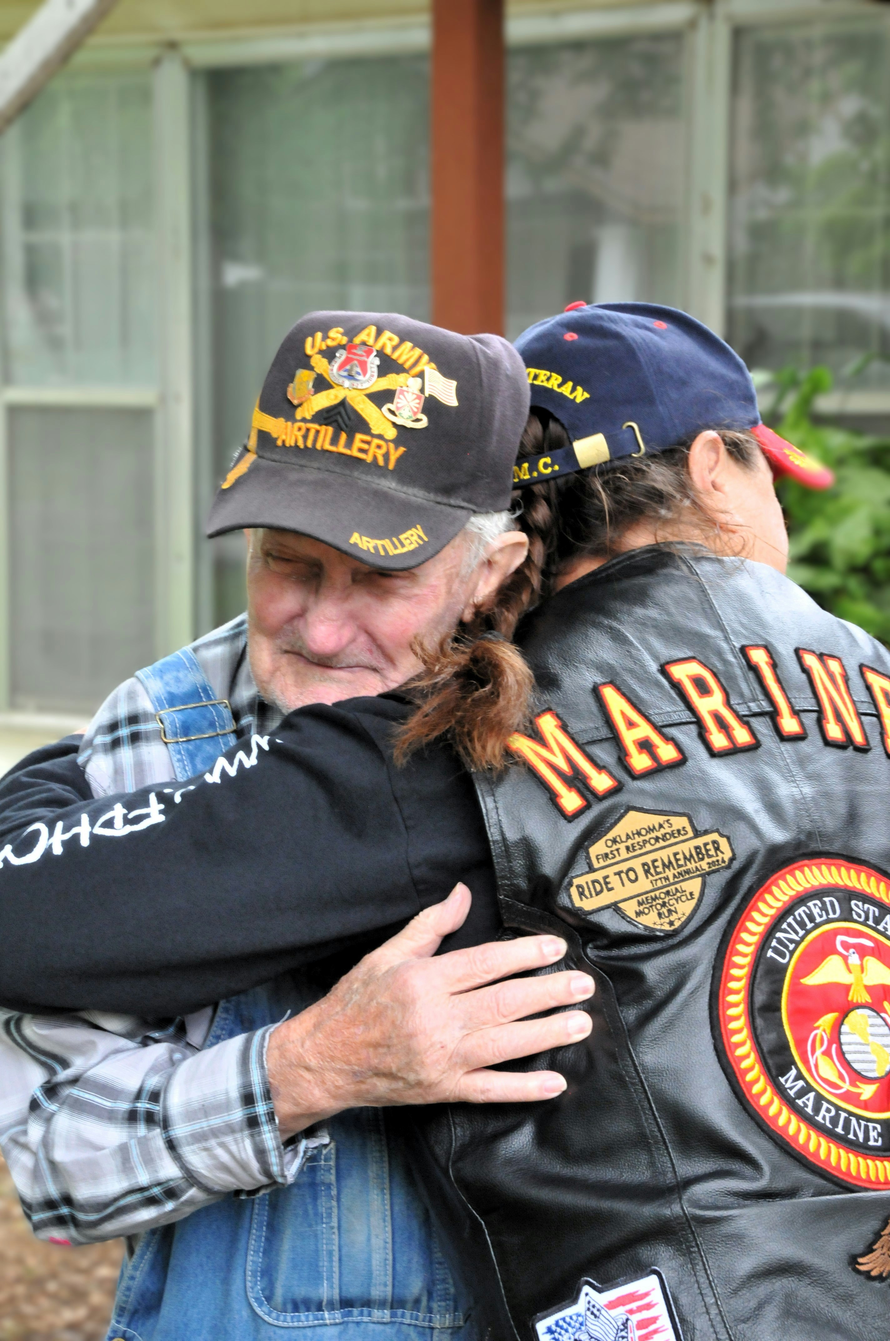 Two men hugging each other in front of a house