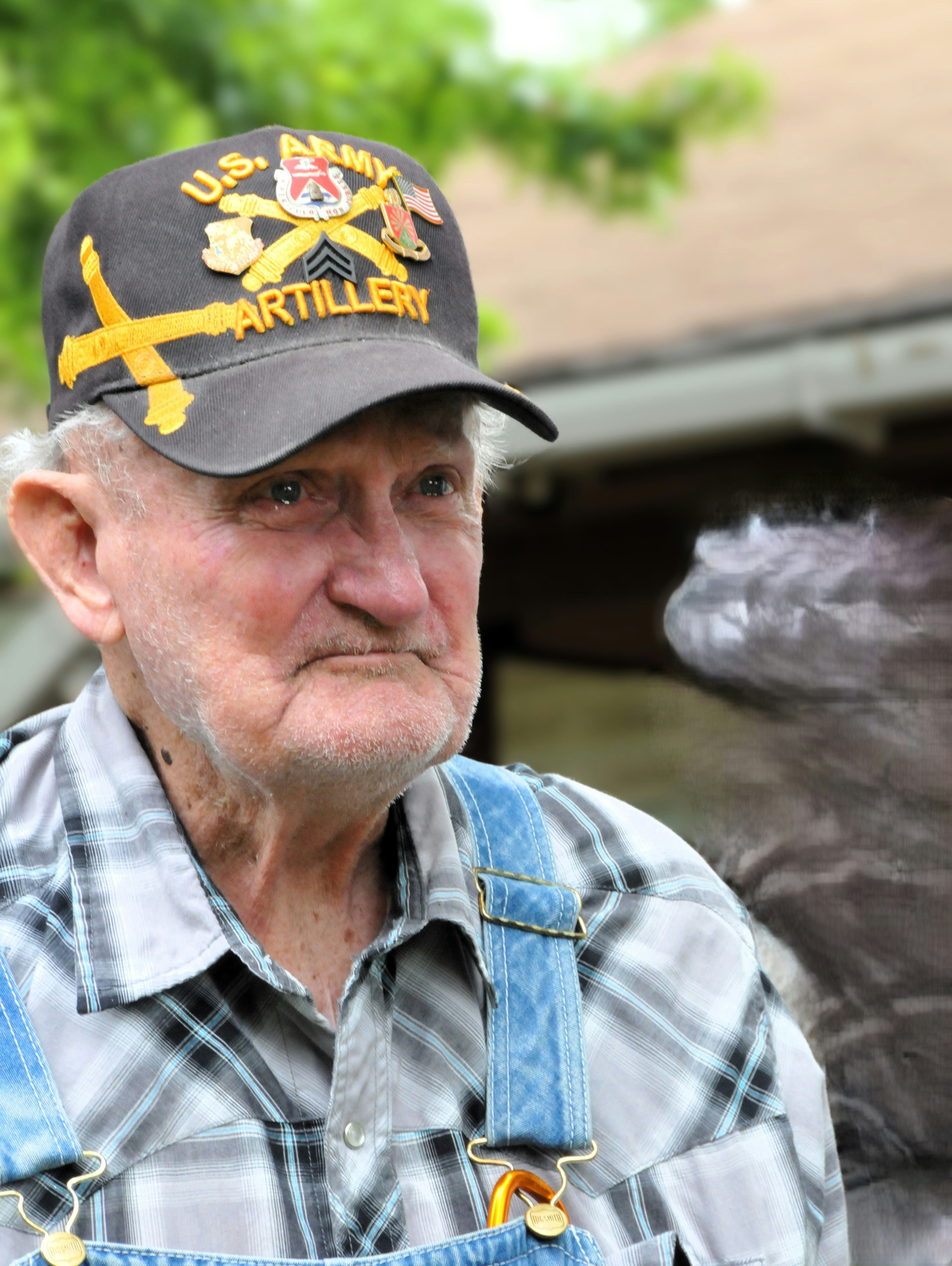 An older man wearing overalls and a hat