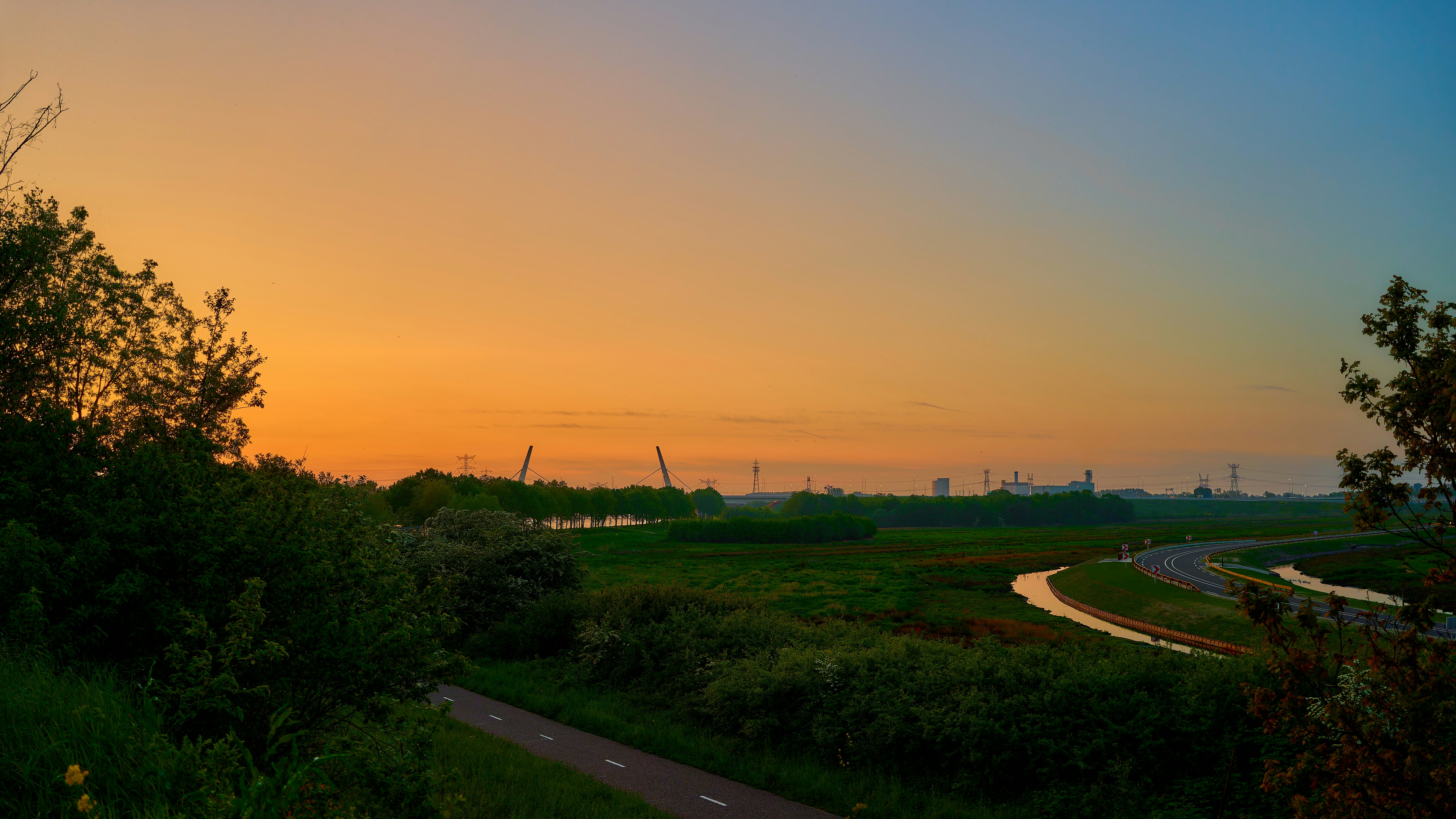 The sun is setting over a winding road