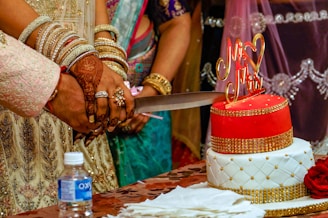 A couple of people that are cutting a cake