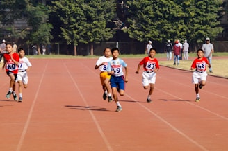 A group of young men running across a track