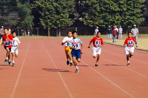 A group of young men running across a track