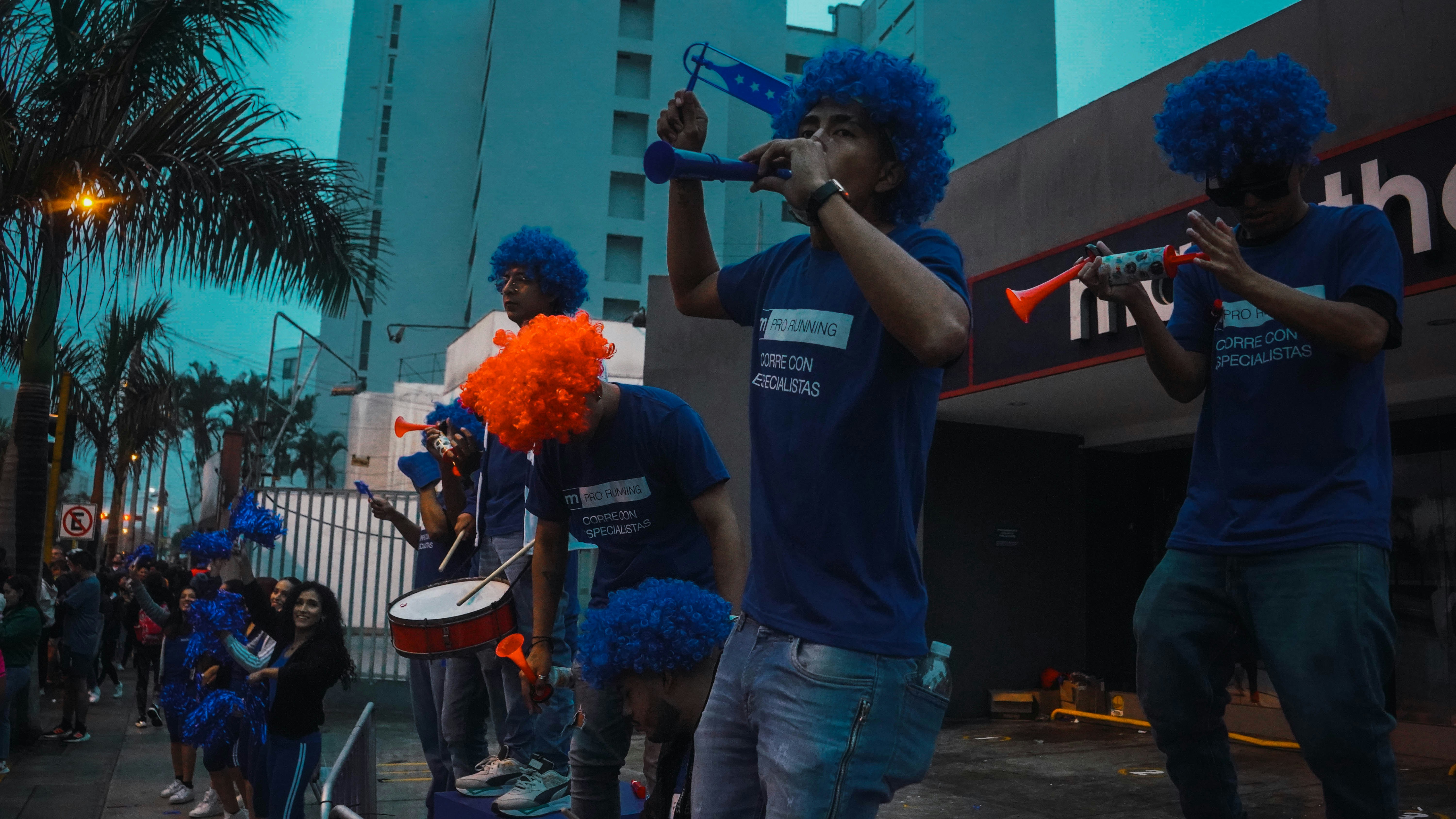 Sekelompok orang dengan kemeja biru dan wig oranye