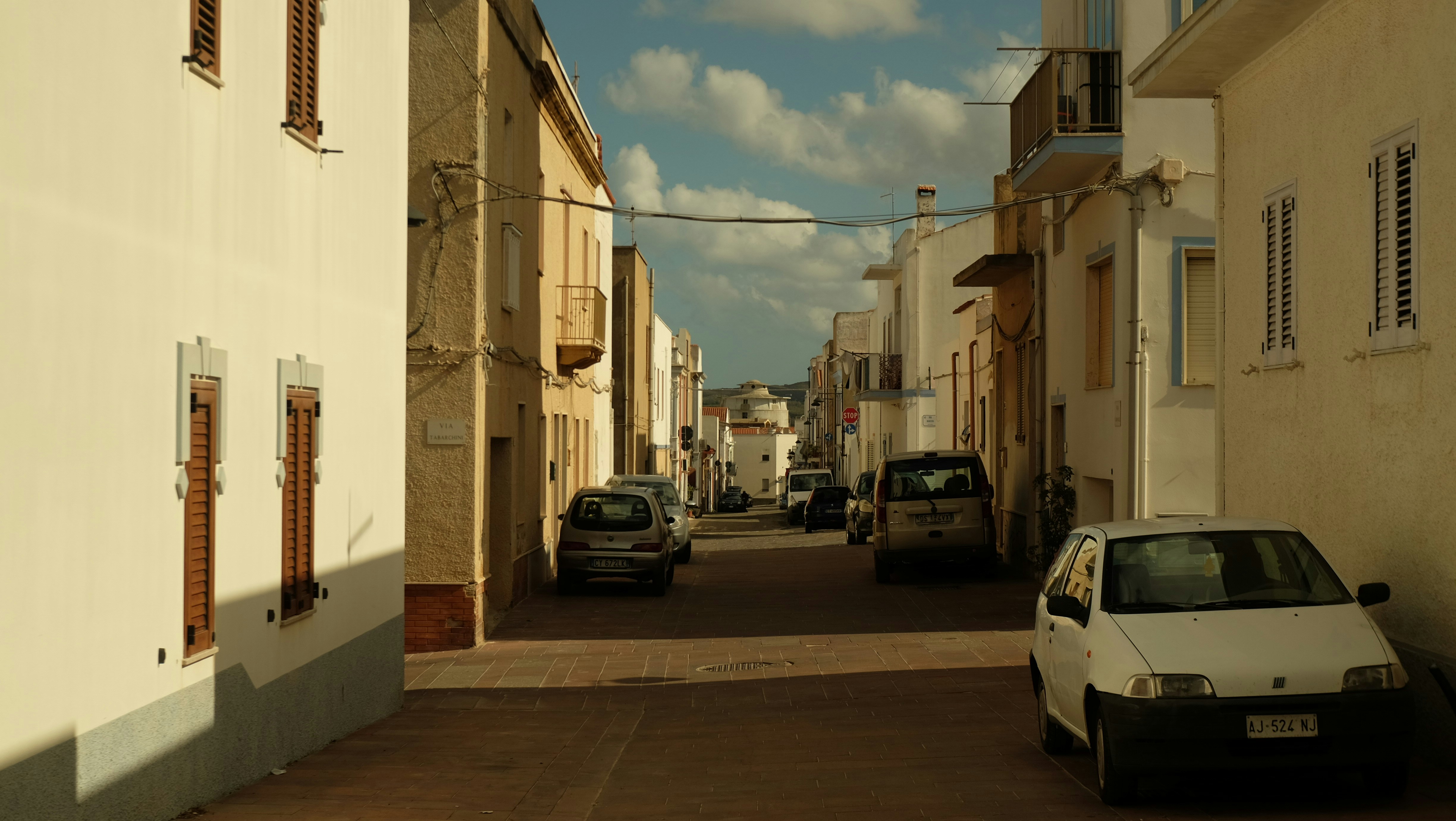 A car parked on the side of a road next to a building, 