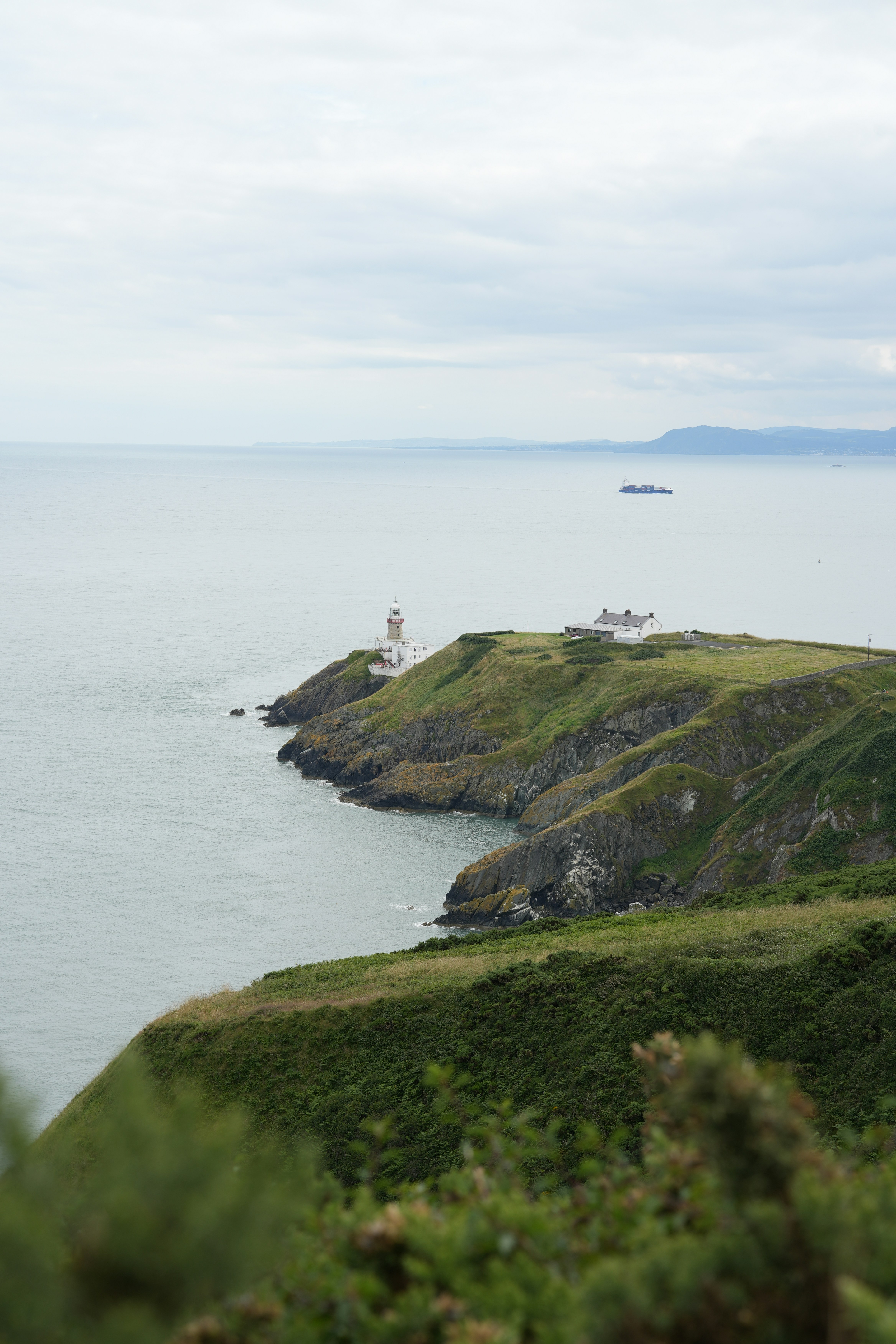 A lighthouse on a small island in the middle of the ocean