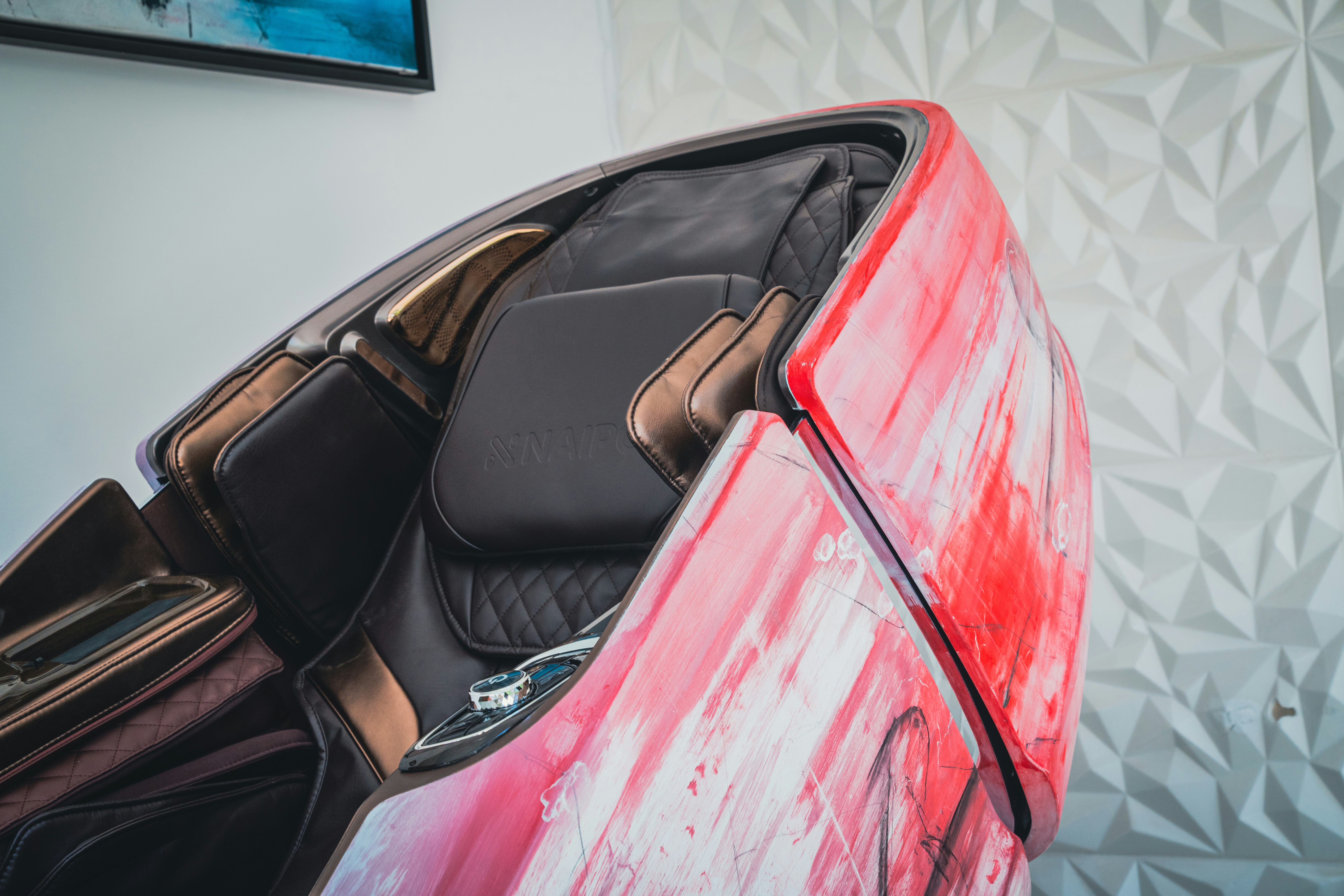 Ein rotes Auto, das vor einer weißen Wand parkt