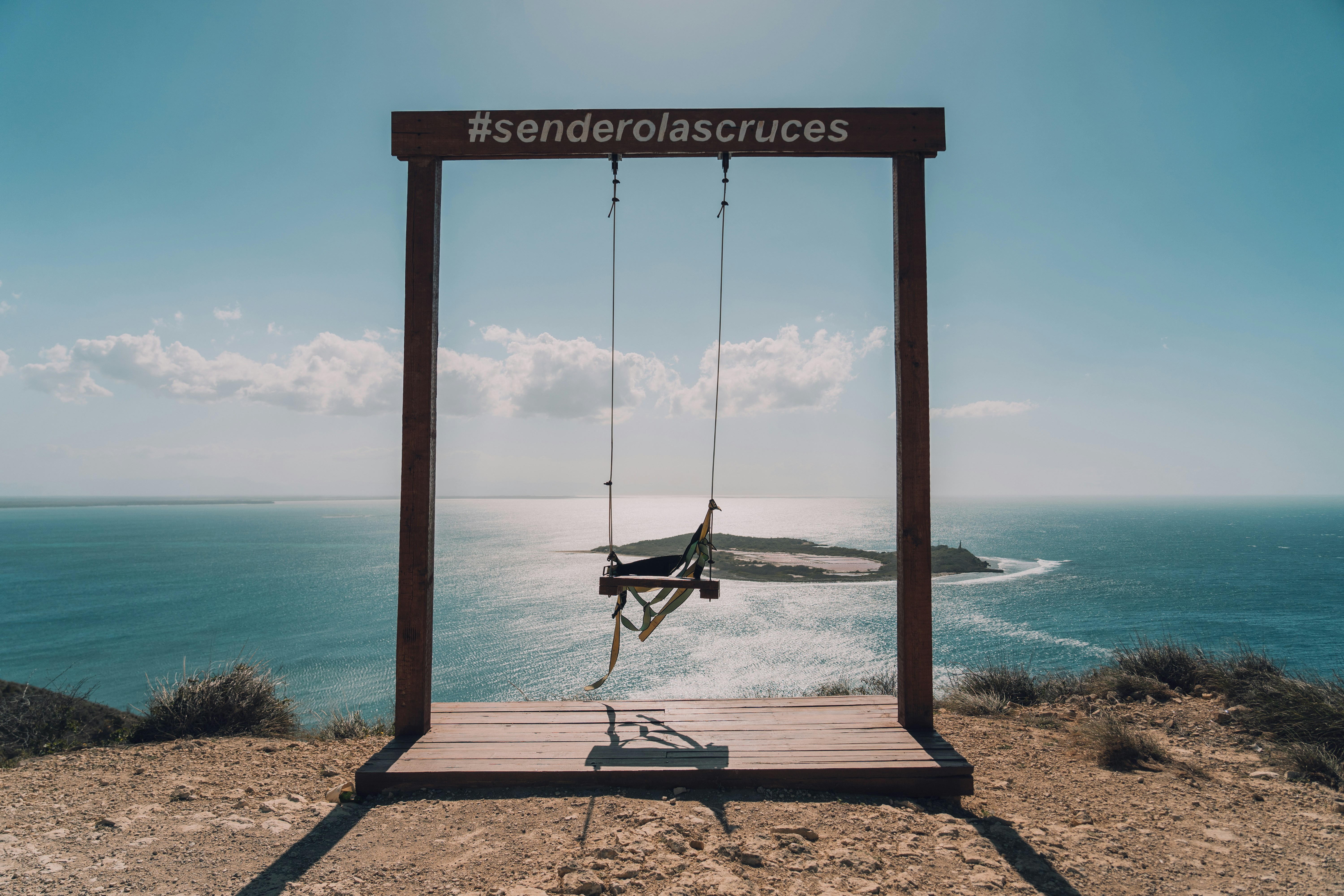 A picture of a swing suspended over a body of water