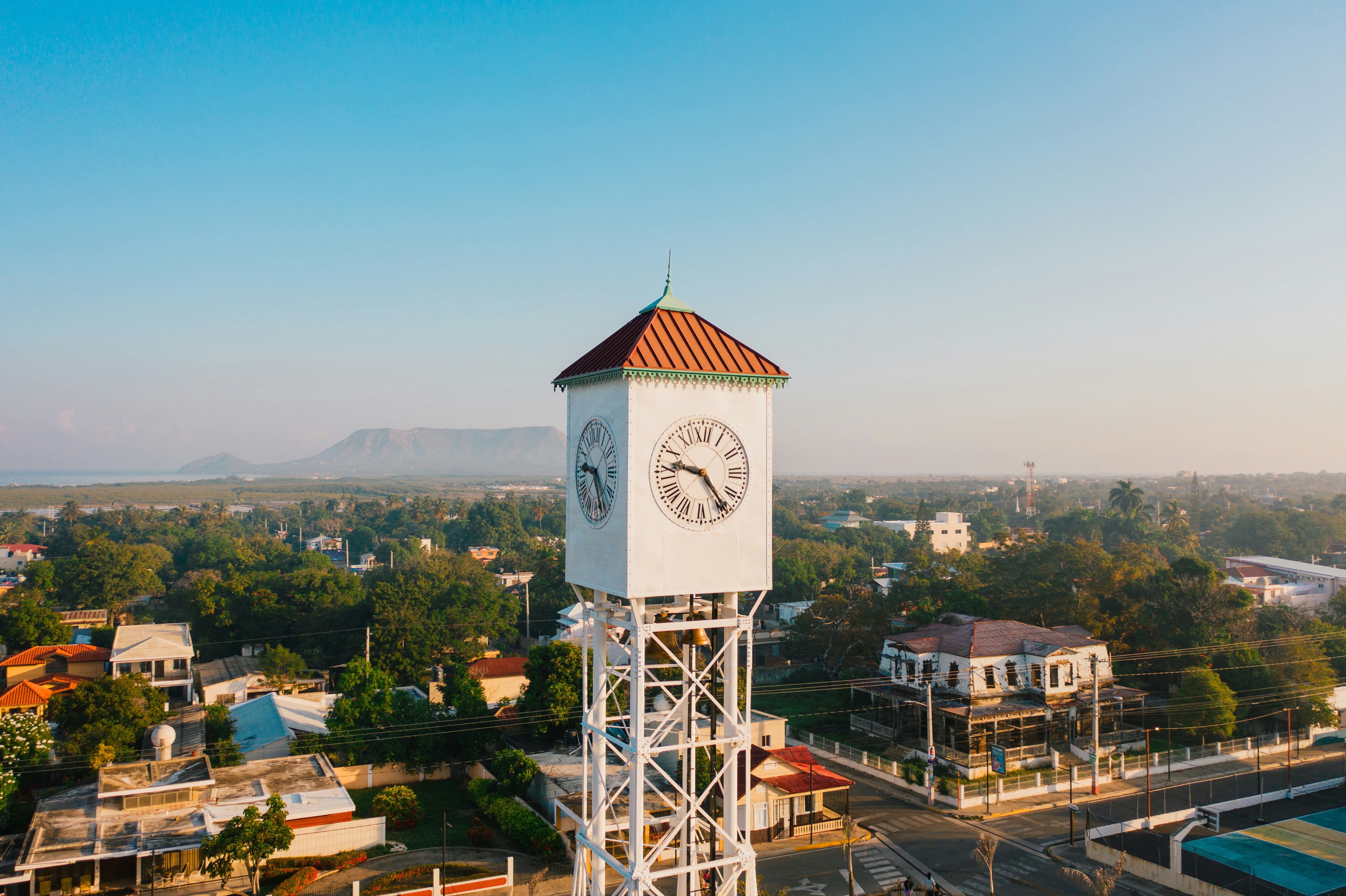 A white clock tower in the middle of a town