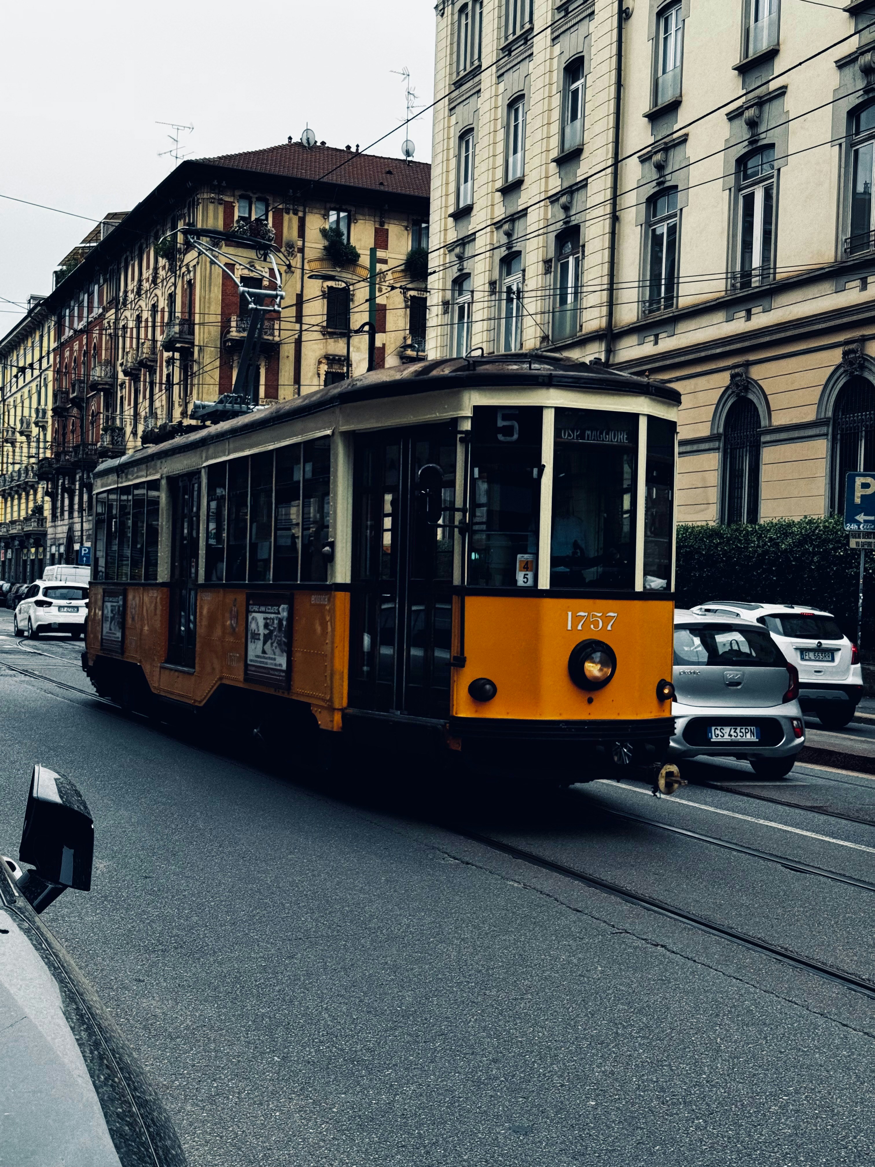 A yellow and black trolley on a city street